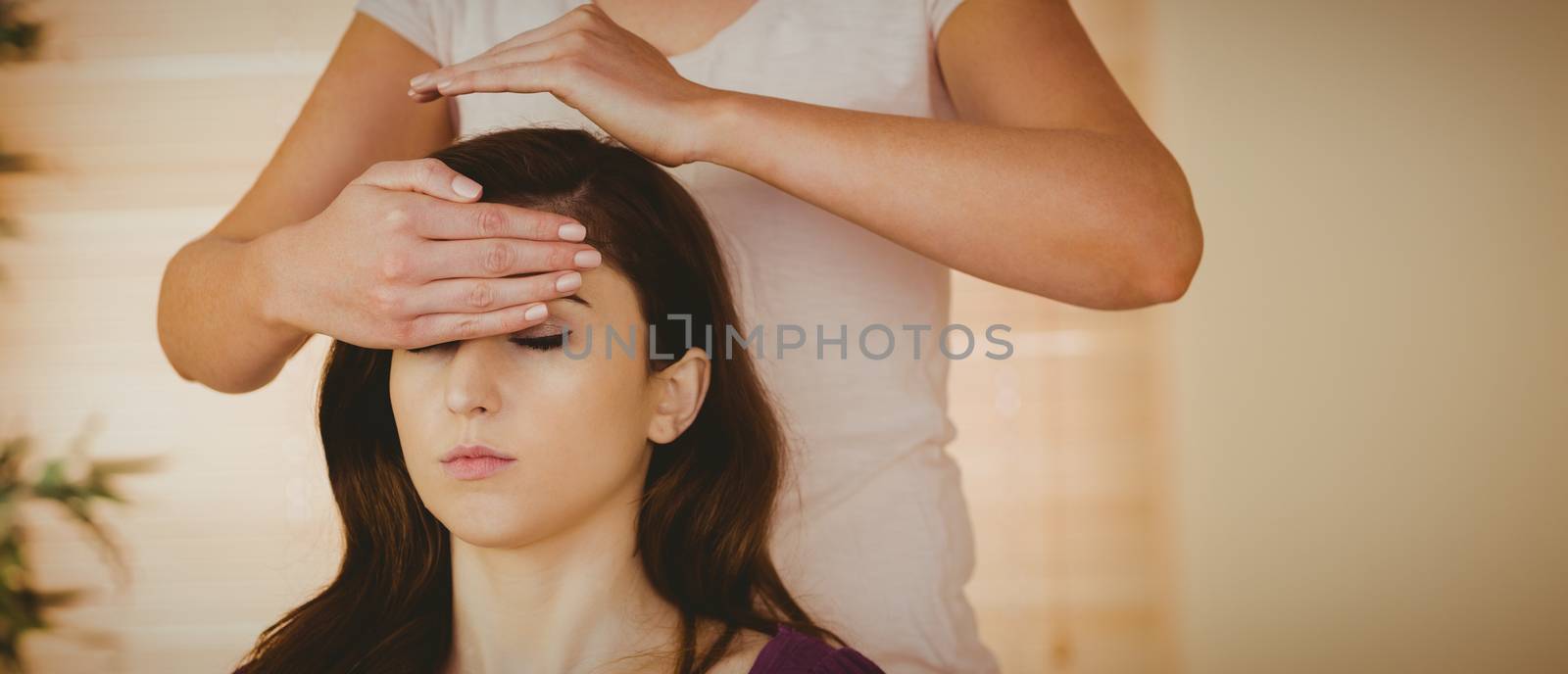 Young woman having a reiki treatment by Wavebreakmedia