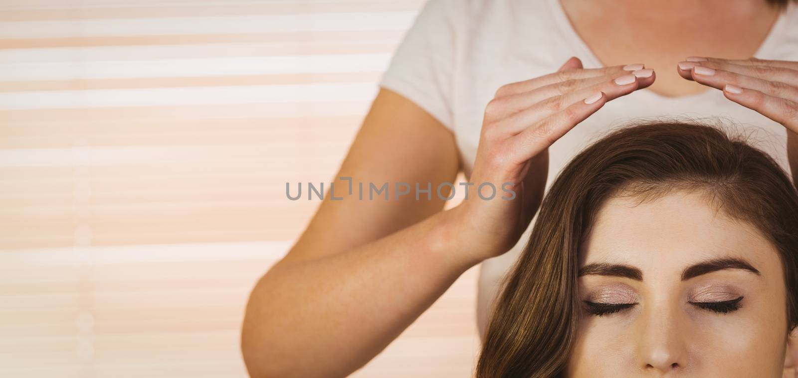 Young woman having a reiki treatment in therapy room