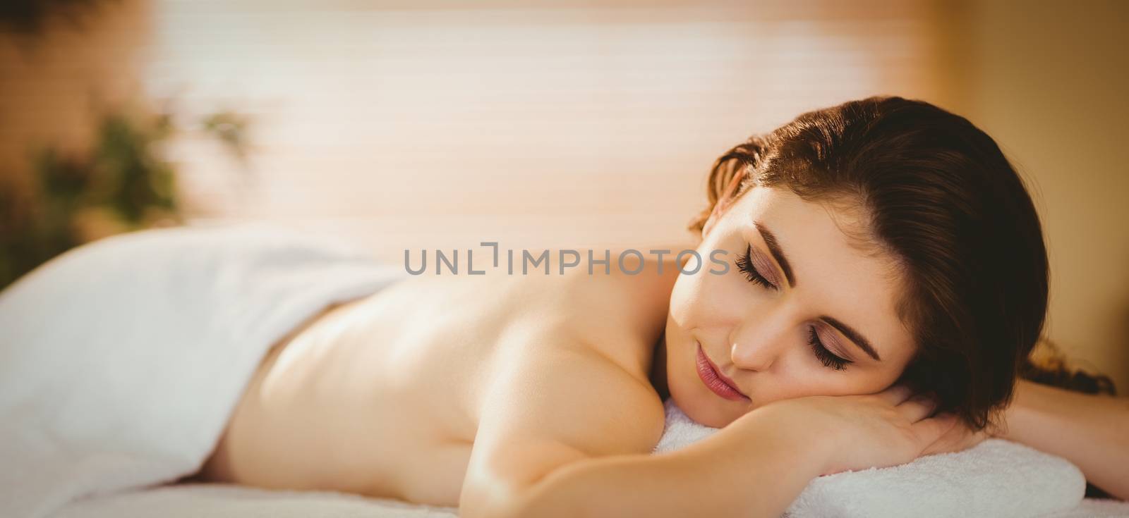 Young woman lying on massage table in therapy room