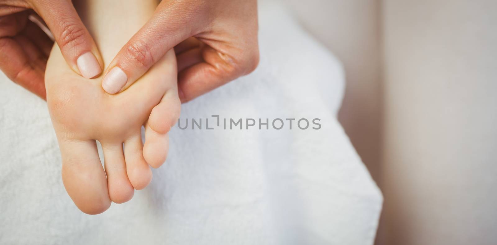 Young woman getting foot massage in therapy room