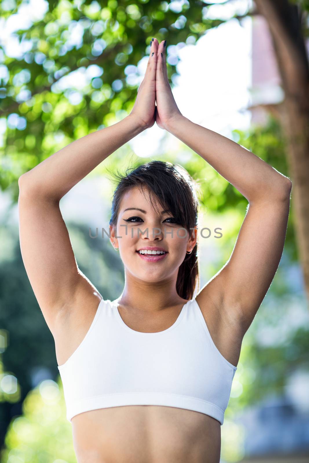 Portrait of smiling athletic woman doing yoga in the city