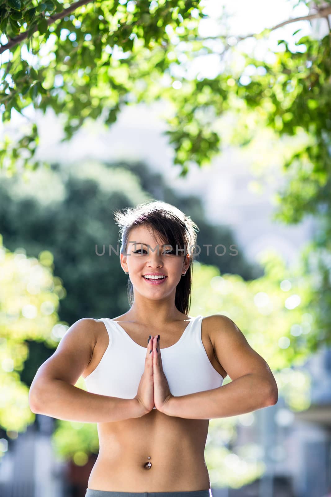 Portrait of smiling athletic woman doing yoga in the city