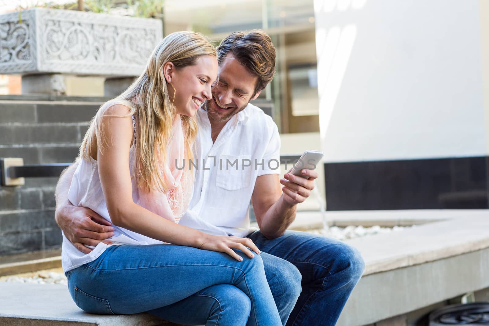 Happy couple sitting and laughing together at shopping mall