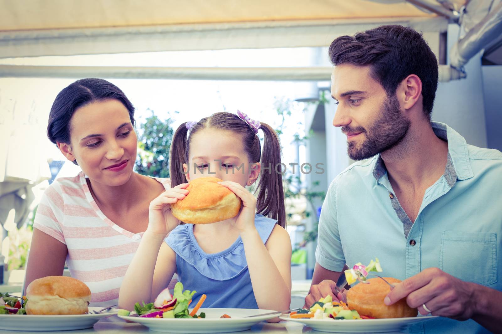 A family eating at the restaurant on a sunny day