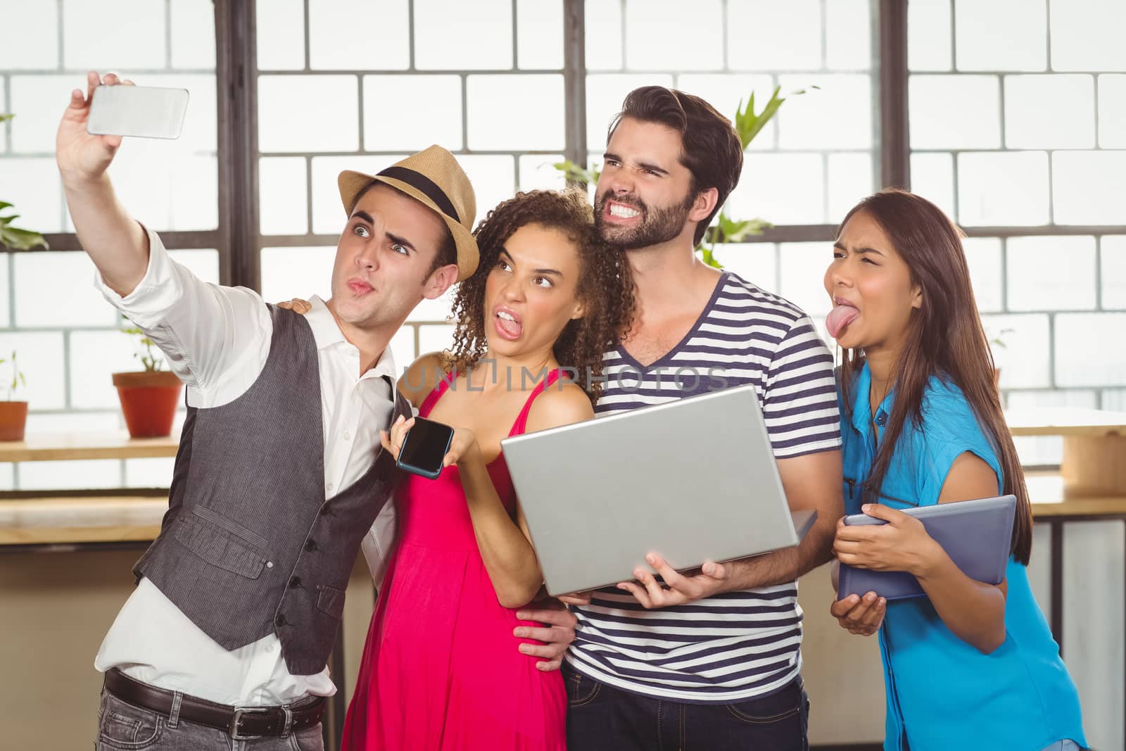 Grimacing friends taking selfies at coffee shop