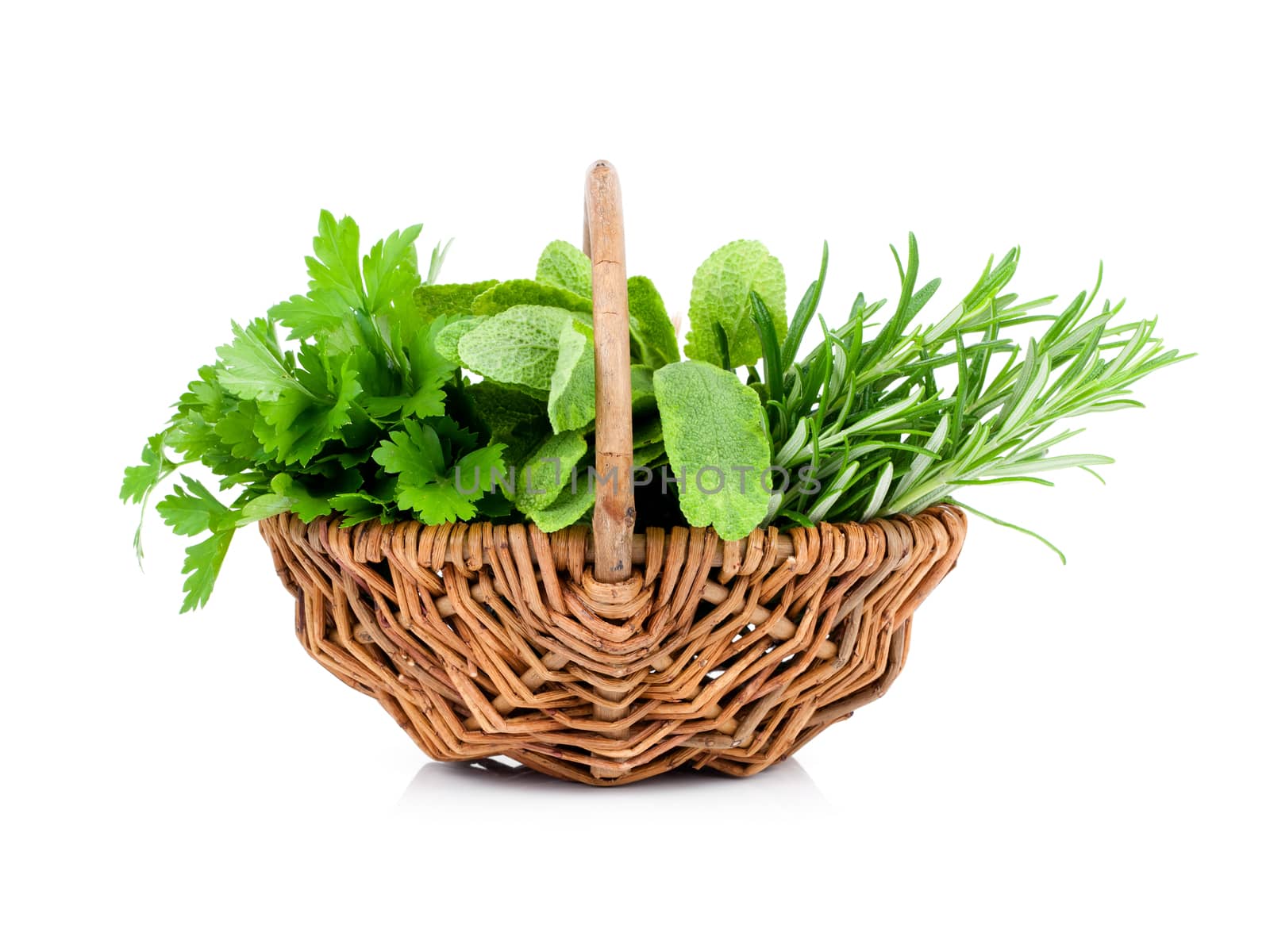sage, parsley and rosemary in wicker basket, on a white background