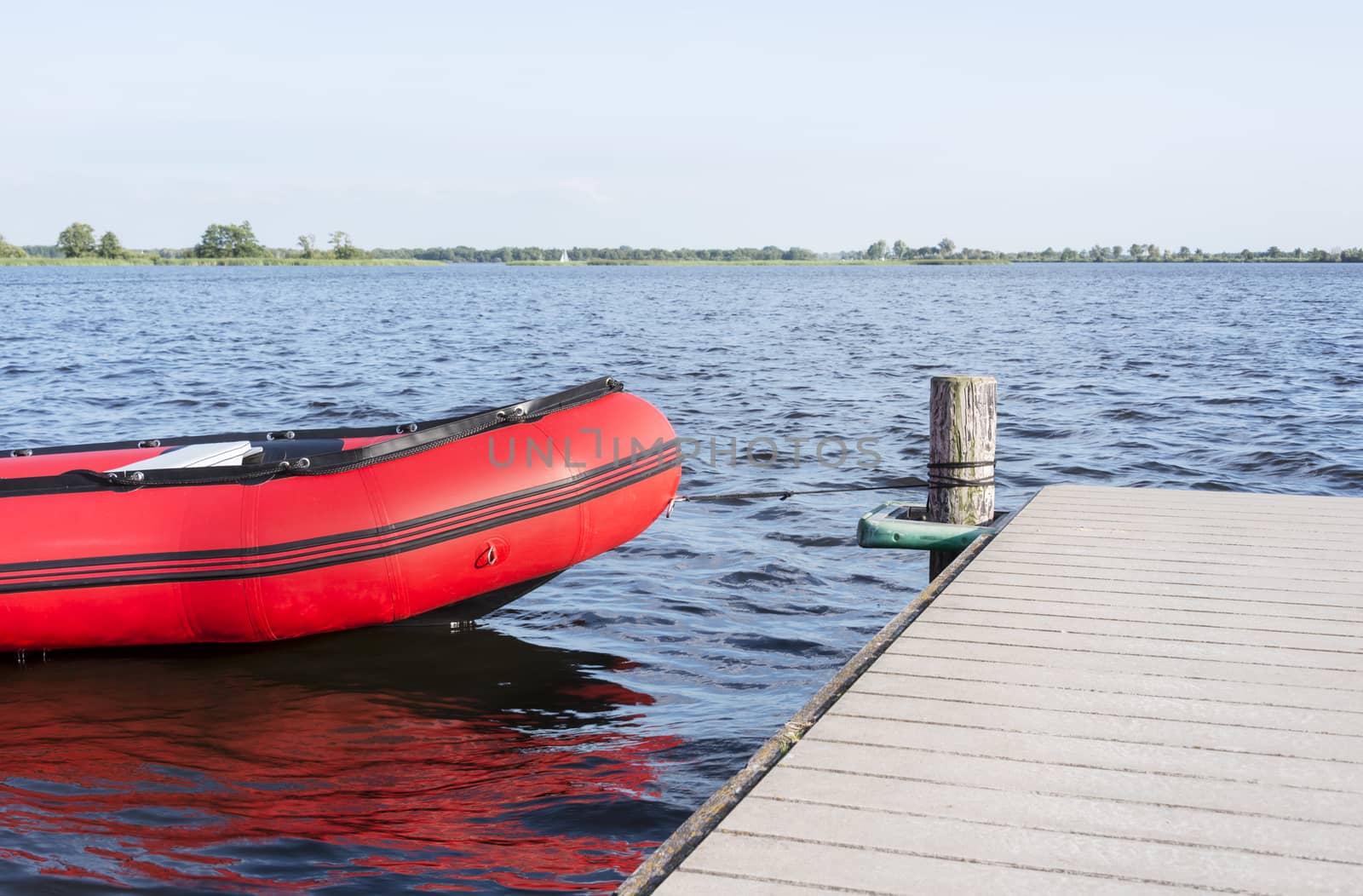 inflatable red boat in the belterwiede lake in holland near giethoorn