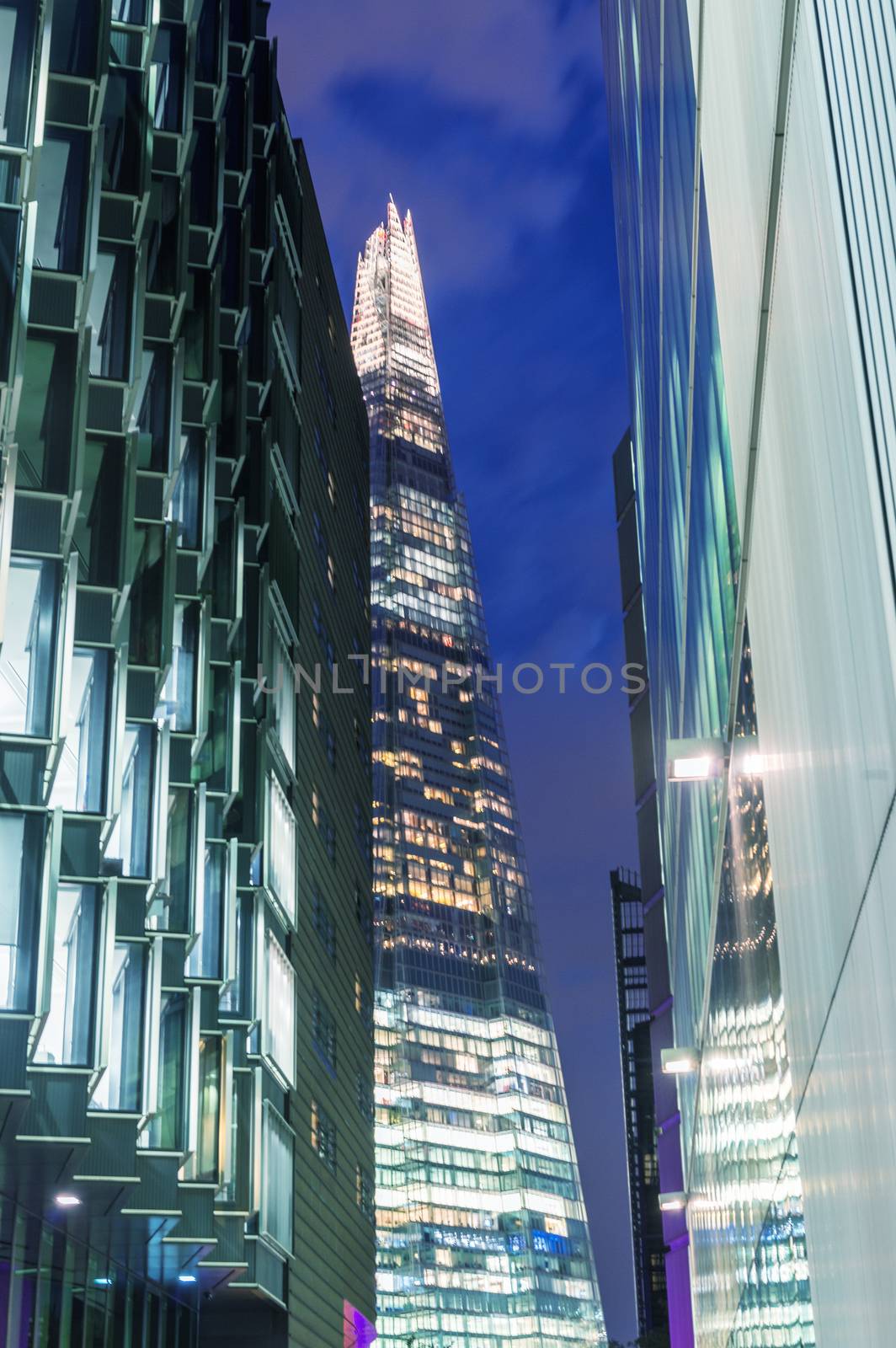 LONDON - JUNE 12, 2015: The Shard at night framed by buildings. by jovannig