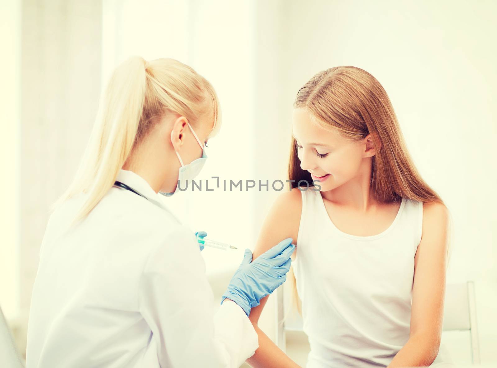 doctor doing vaccine to child in hospital by dolgachov