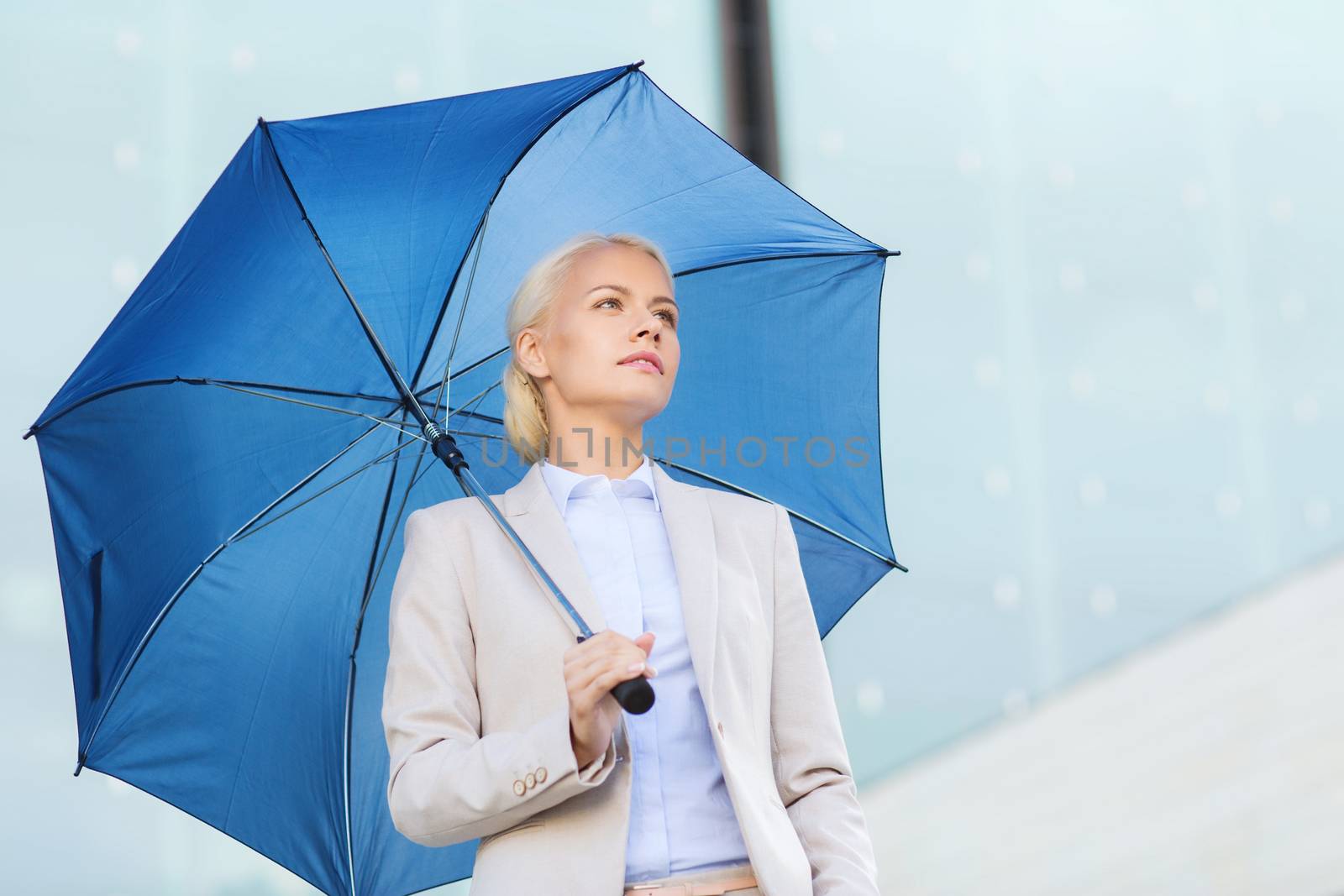 young serious businesswoman with umbrella outdoors by dolgachov