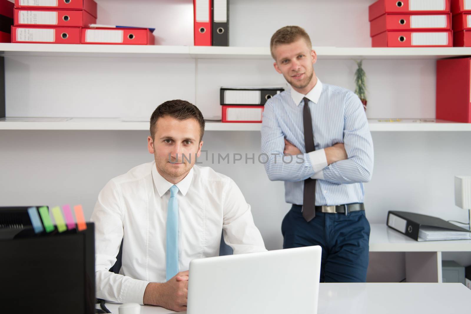 Two Businessmen In An Office Smiling by JalePhoto
