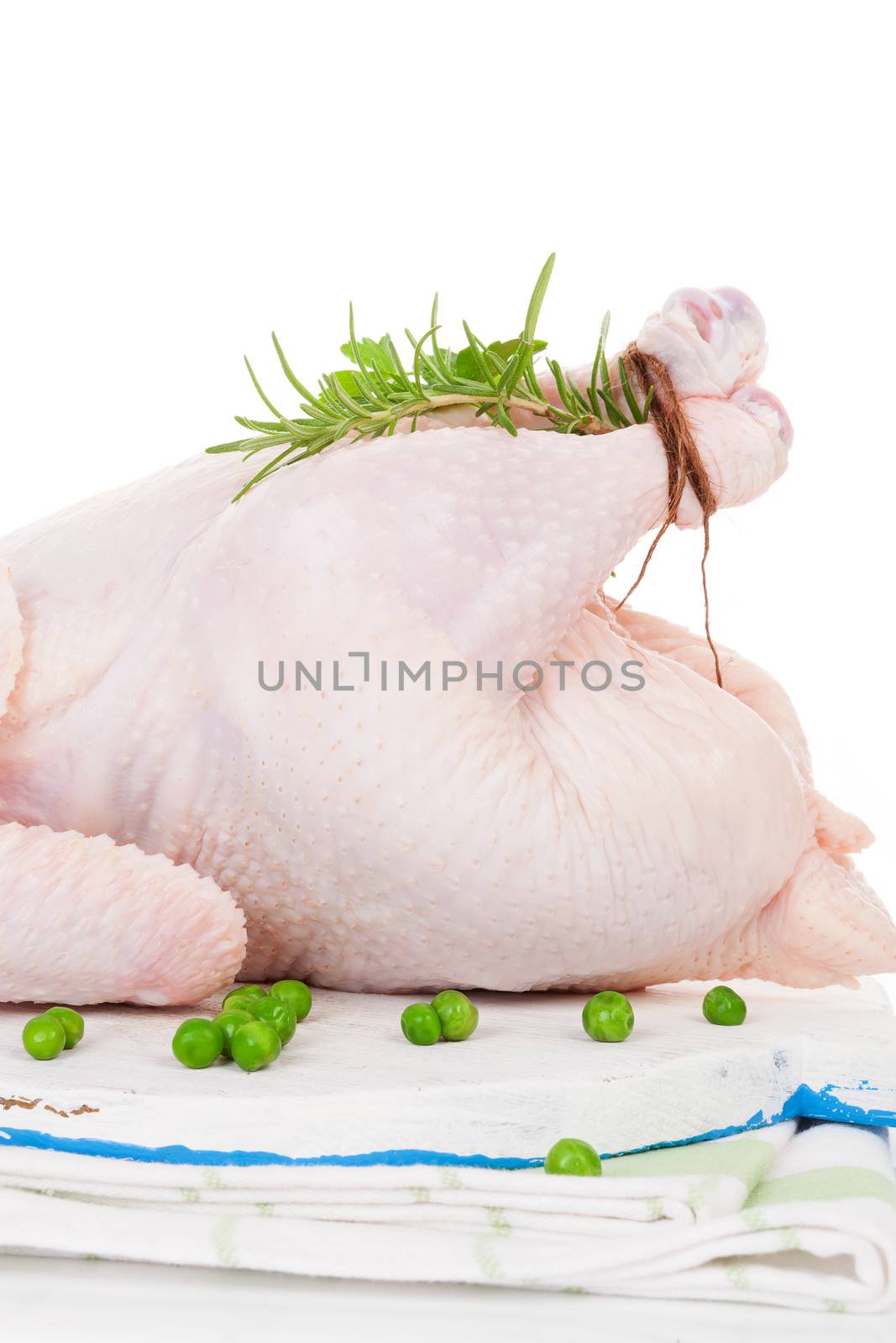 Raw organic whole chicken with herbs on cutting board isolated on white, prepared for baking. Culinary cooking.