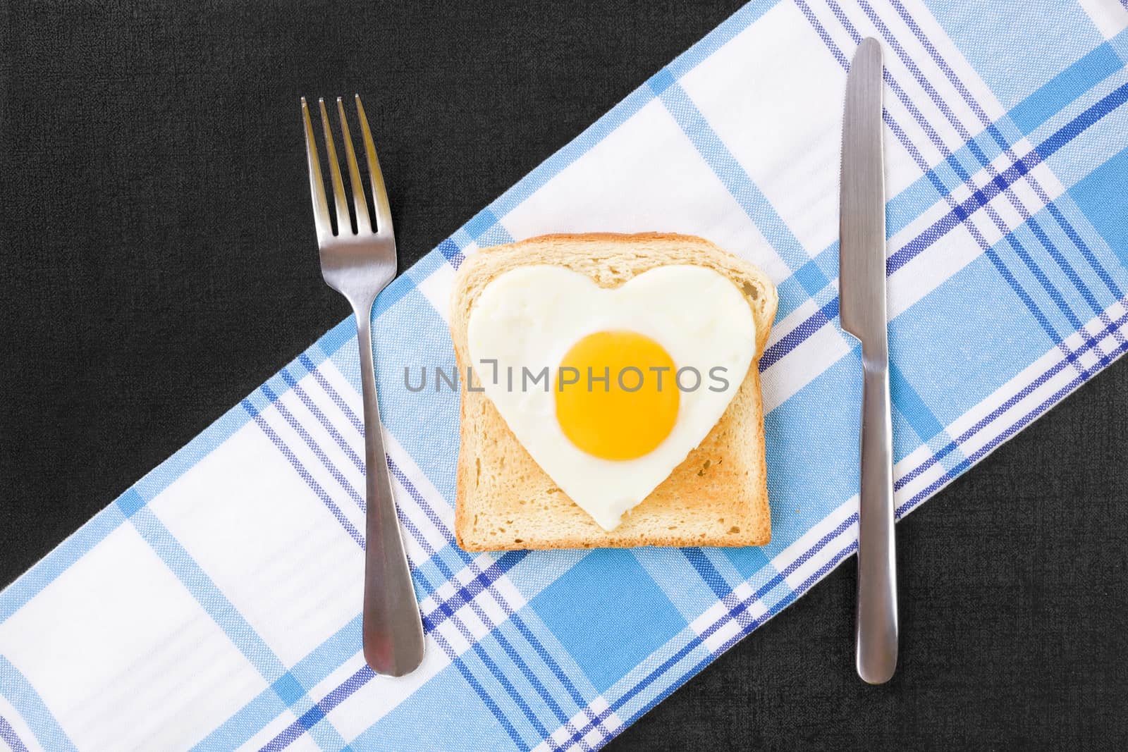 Sunny side up egg in heart shape on toast, top view. I love breakfast. Fresh modern image language. Culinary arts. 