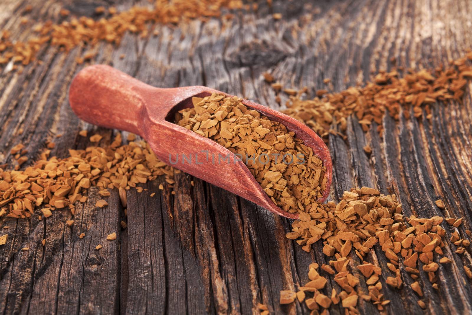 Instant coffee on wooden scoop on old wooden background. Culinary coffee background. 