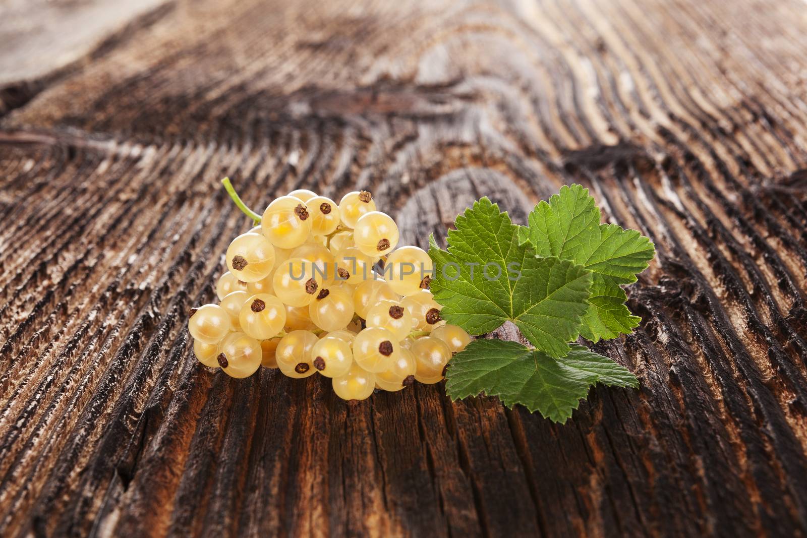 Ripe white currant on old vintage wooden background. Healthy summer fruit eating. 