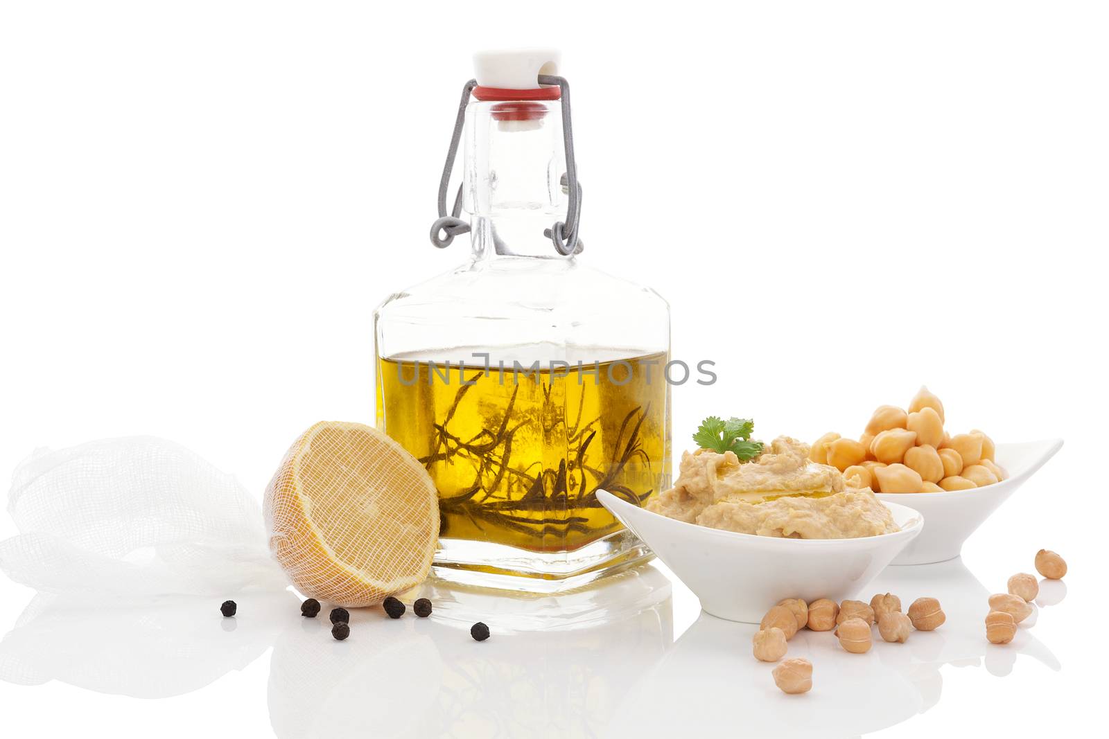 Olive oil, hummus, chickpeas, lemon and pepper corns isolated on white background. Culinary mediterranean cuisine. 