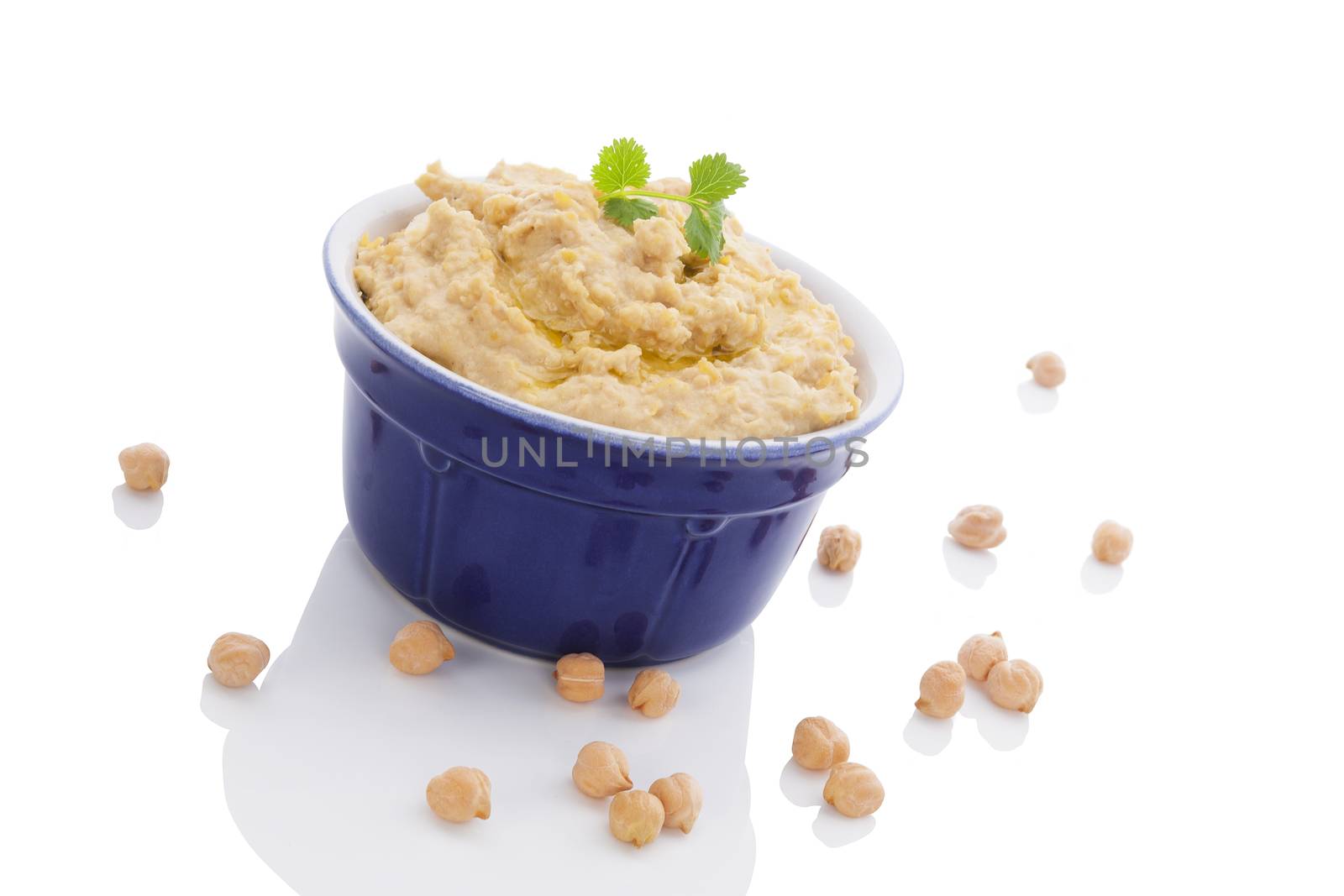 Delicious hummus in ceramic pot and chickpeas isolated on white background. Traditional eastern eating.