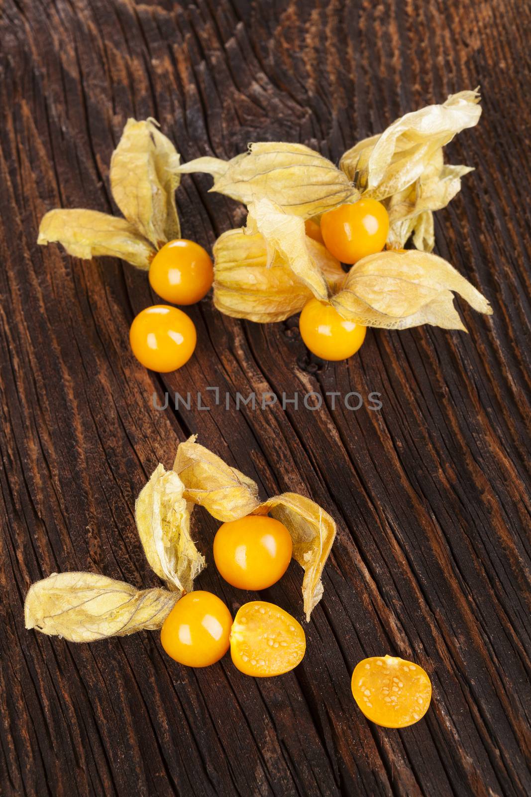 Physalis, groundcherriesl on brown textured aged background. Tropical healthy fruit eating.