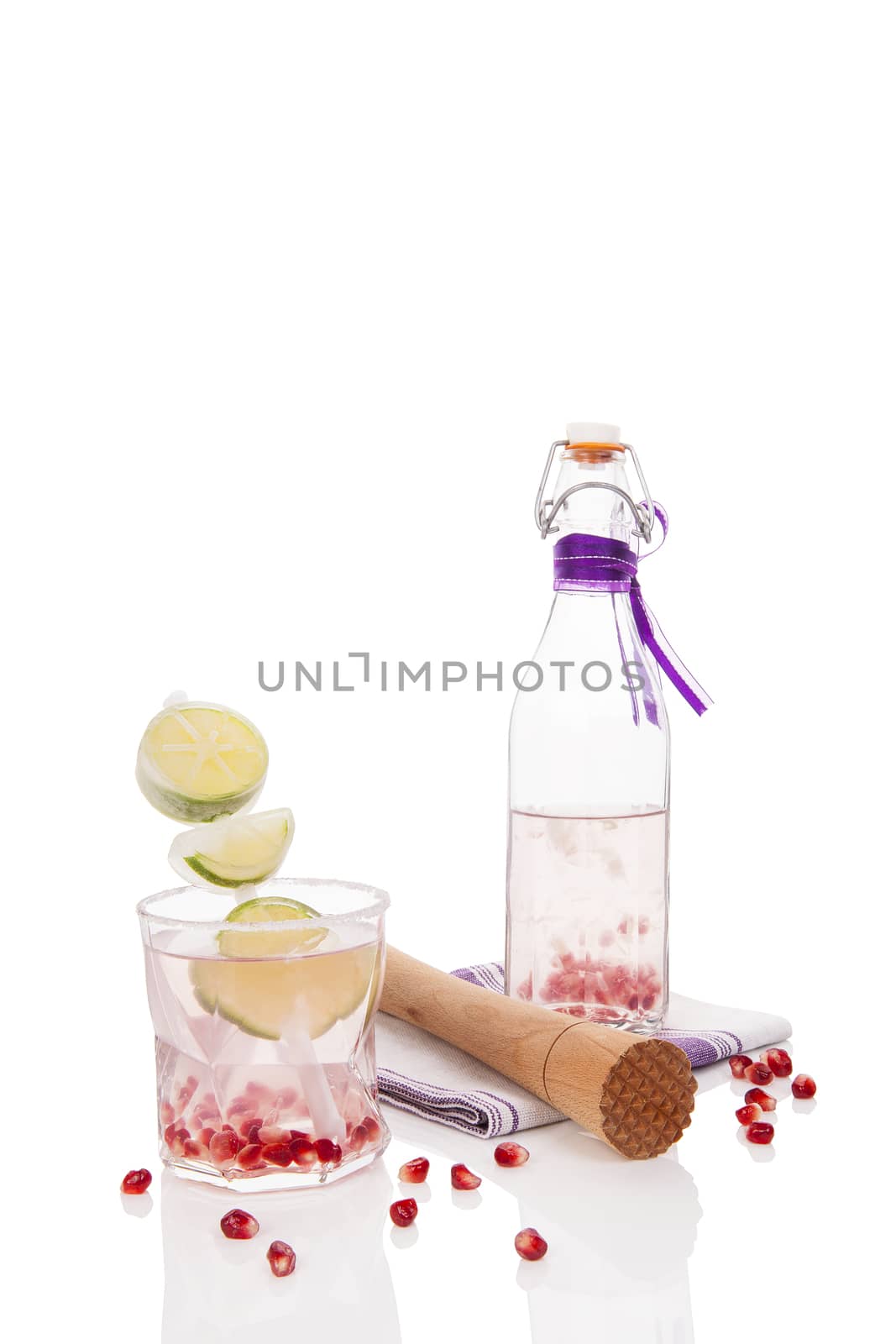 Delicious pomegranate lemonade with lime isolated on white background. Culinary fresh mocktail, non alcoholic summer drink. 