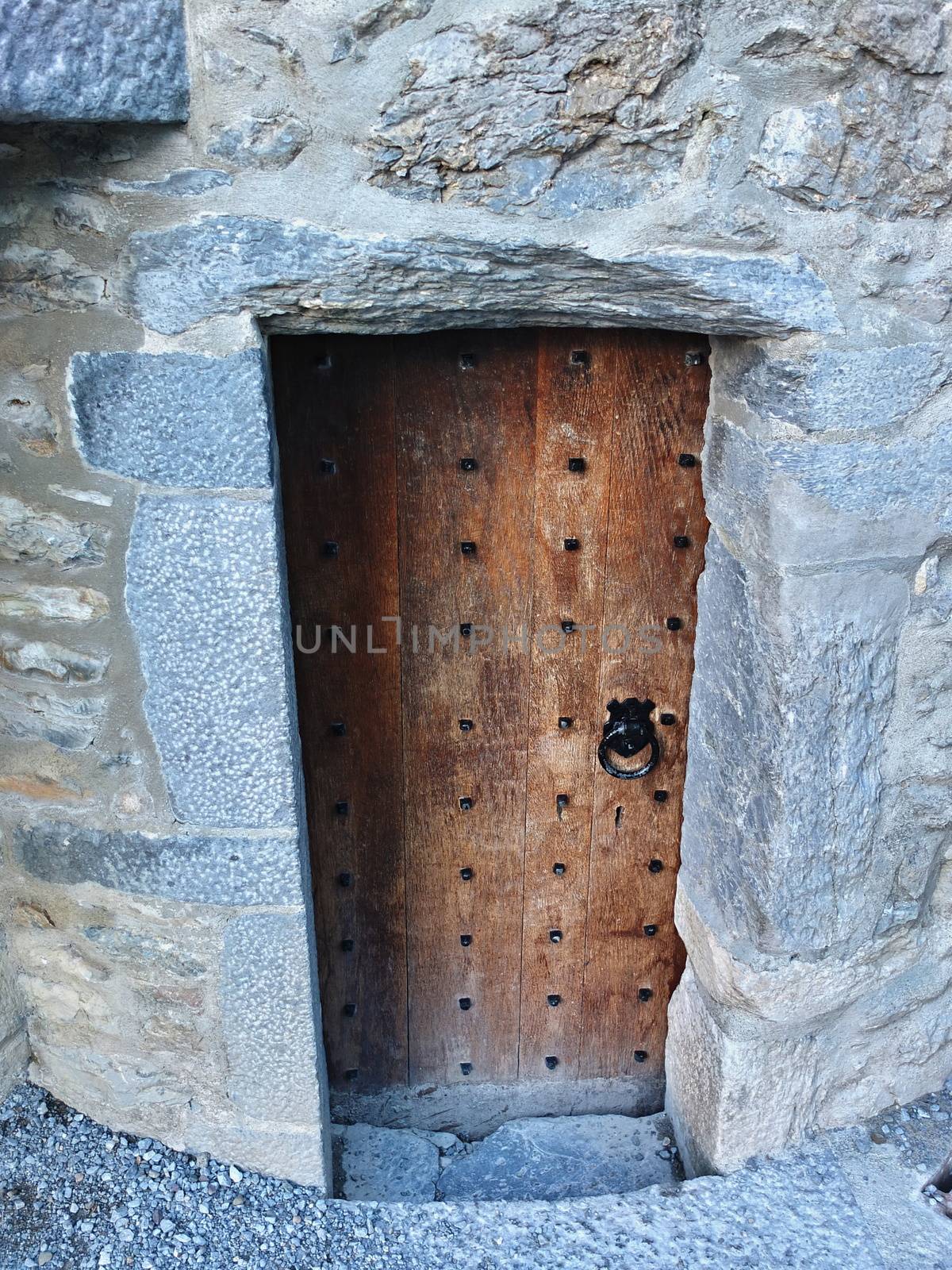 Old Castle wooden Door in stone wall with knocker