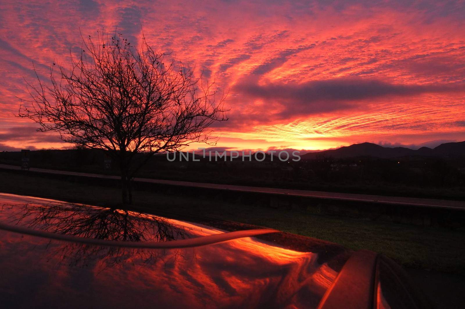 Cloudy Sunrise in Killarney with reflection on the car roof