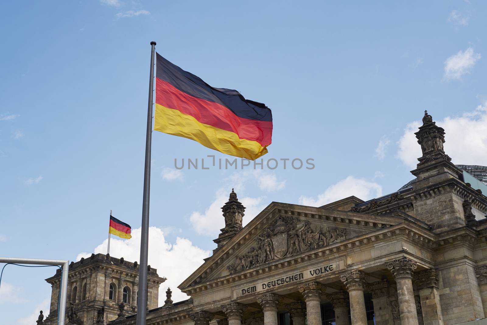 BERLIN, GERMANY - JULY 08: German flag blowing in the wind in front of the Reichstag building. July 08, 2015 in Berlin.