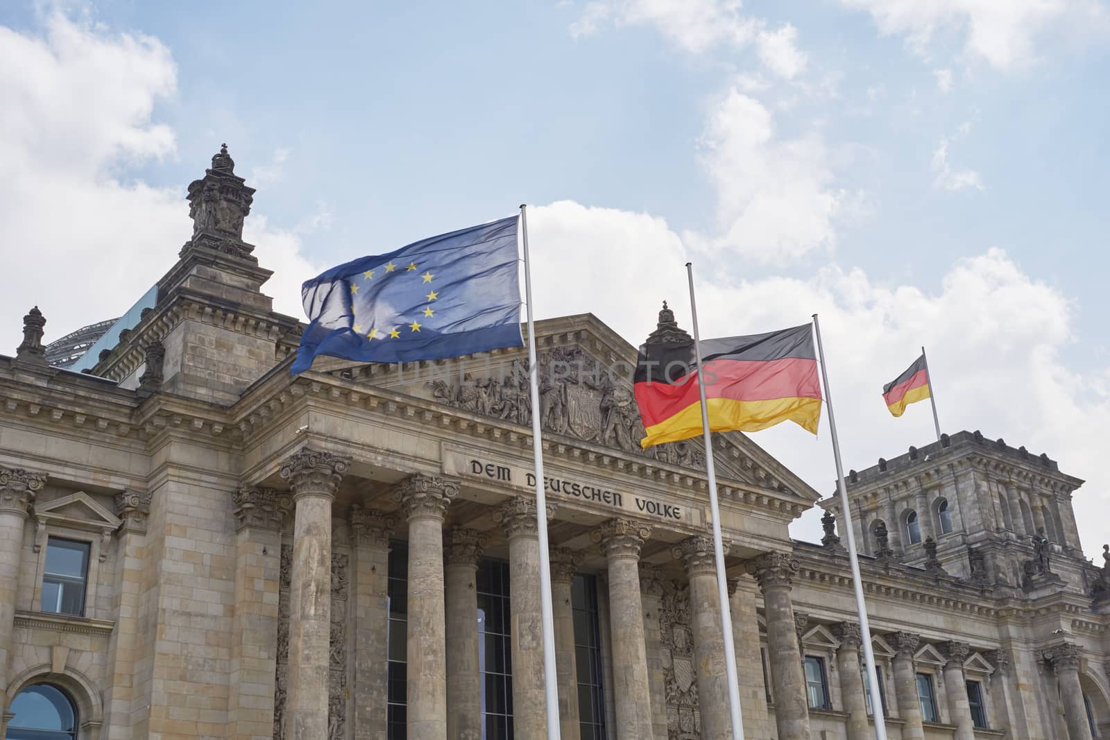 BERLIN, GERMANY - JULY 08: German and EU flags blowing in the wind in front of the Reichstag building. July 08, 2015 in Berlin.