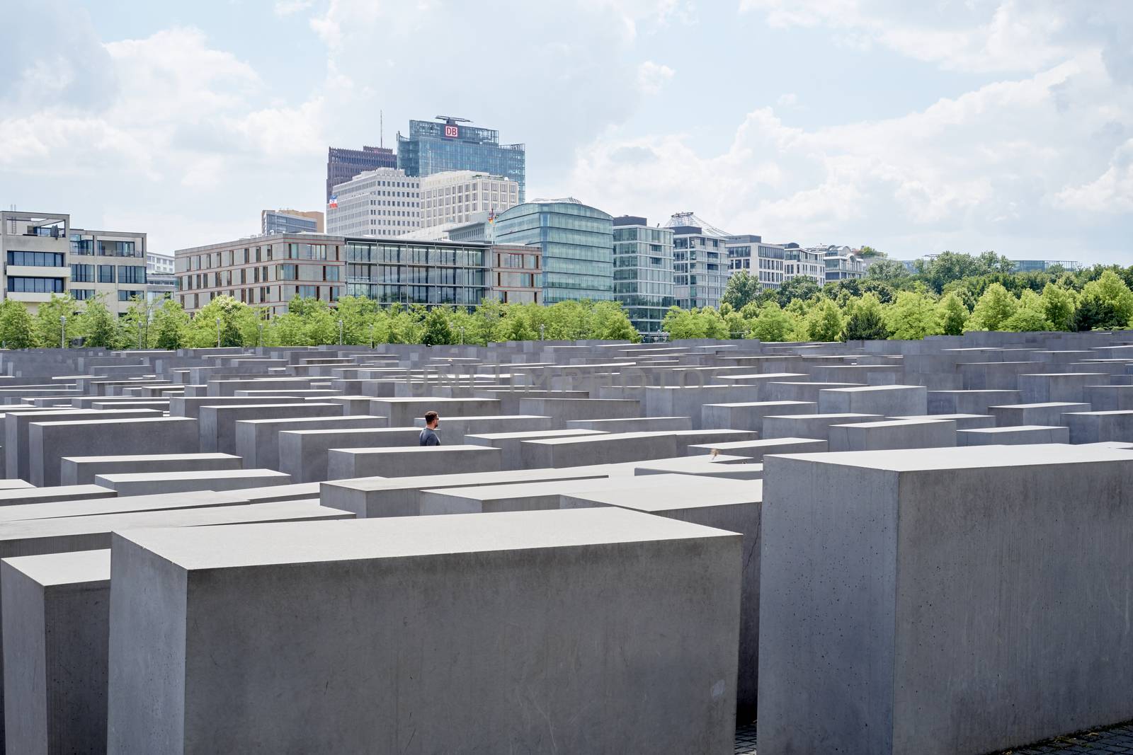BERLIN, GERMANY - JULY 08: Lone man walking among stone blocks at the Memorial to the Murdered Jews of Europe. July 08, 2015 in Berlin.