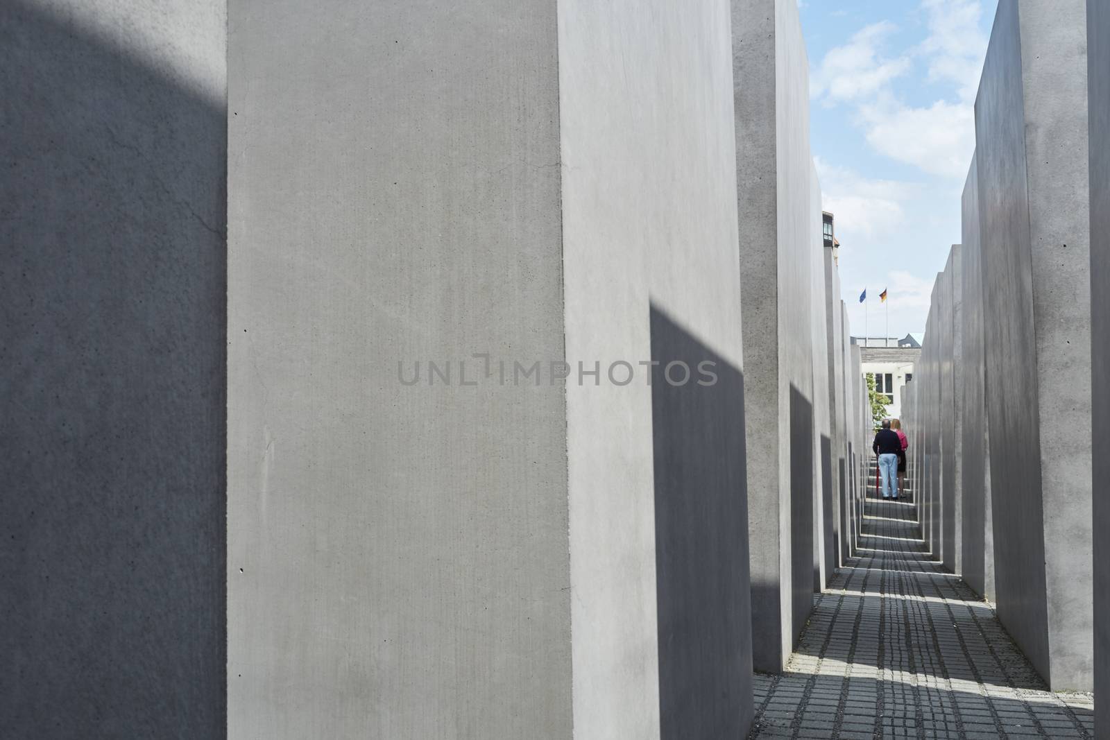 BERLIN, GERMANY - JULY 08: Elderly couple walking among stone blocks at the Memorial to the Murdered Jews of Europe. July 08, 2015 in Berlin.