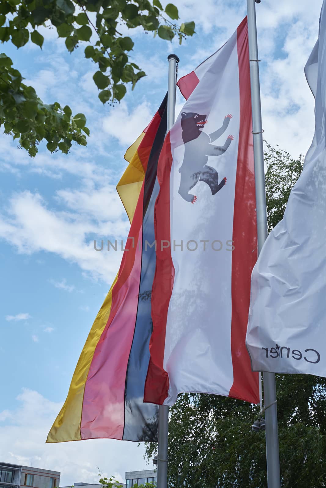 BERLIN, GERMANY - JULY 08: City of Berlin banner blowing in the wind next to German banner. July 08, 2015 in Berlin.
