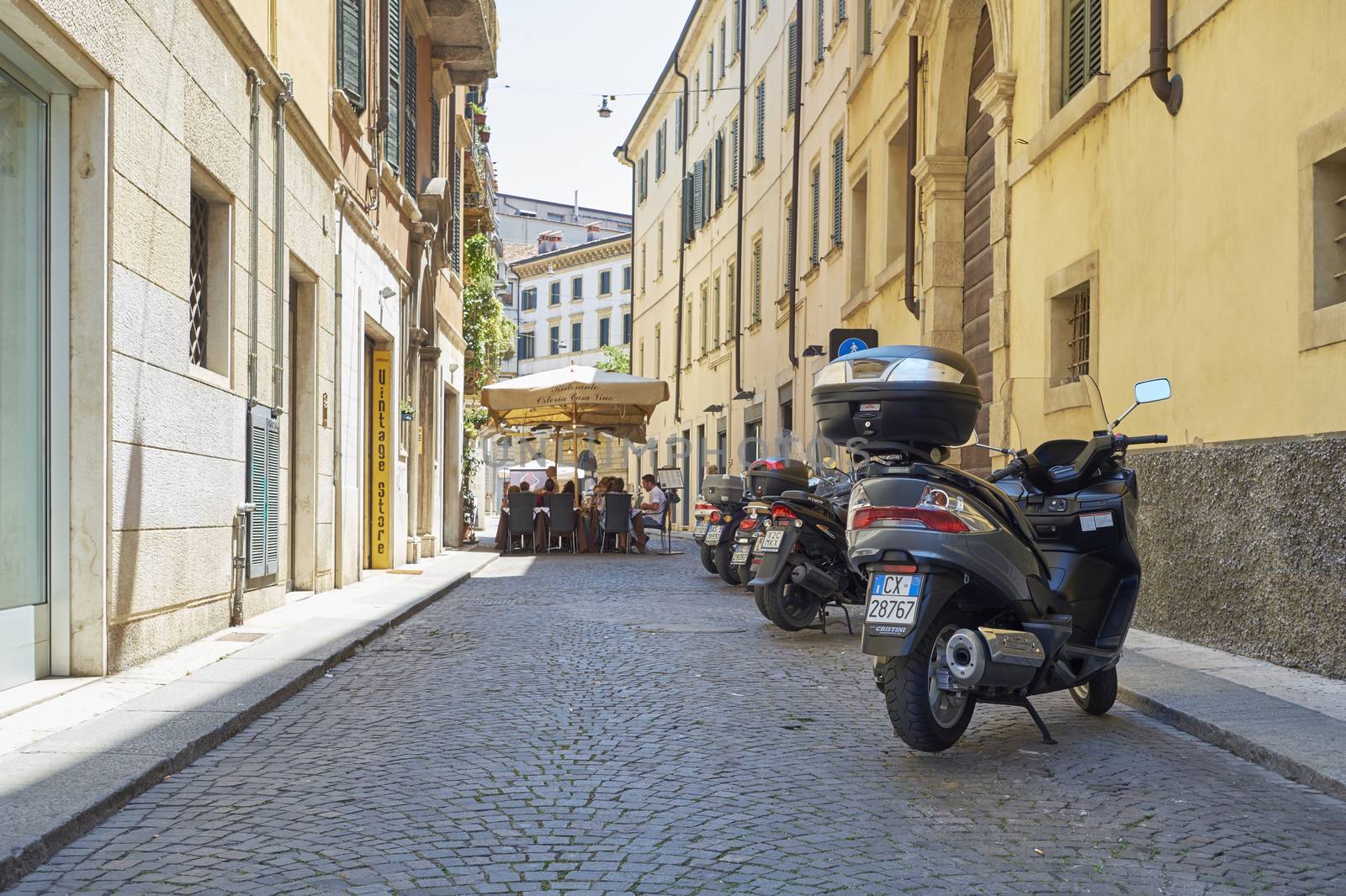 VERONA, ITALY - JULY 11: Low angle shot of stone street with scooters parked. July 11, 2015 in Verona.