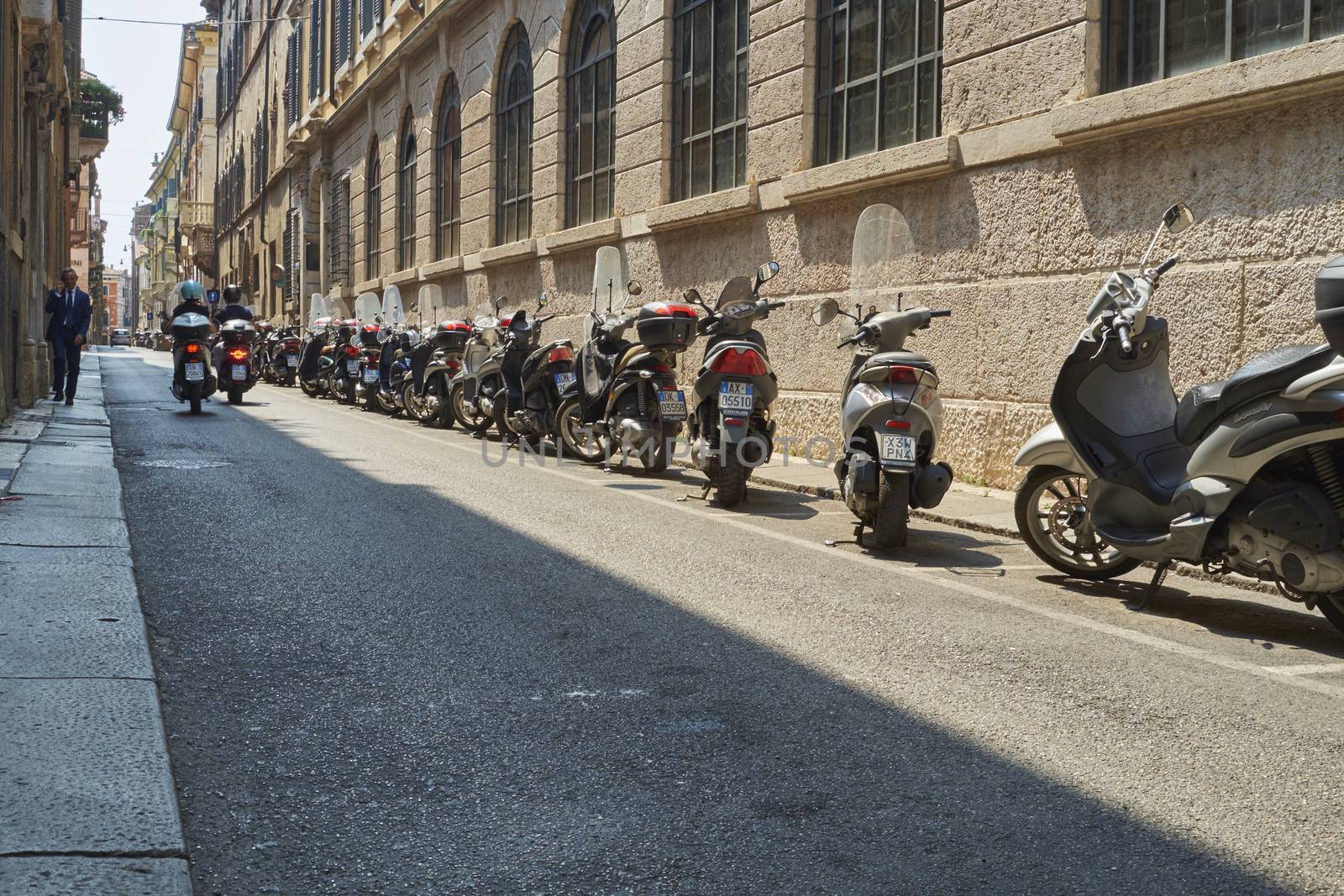 VERONA, ITALY - JULY 13: Low angle shot of street with scooters parked. July 13, 2015 in Verona.