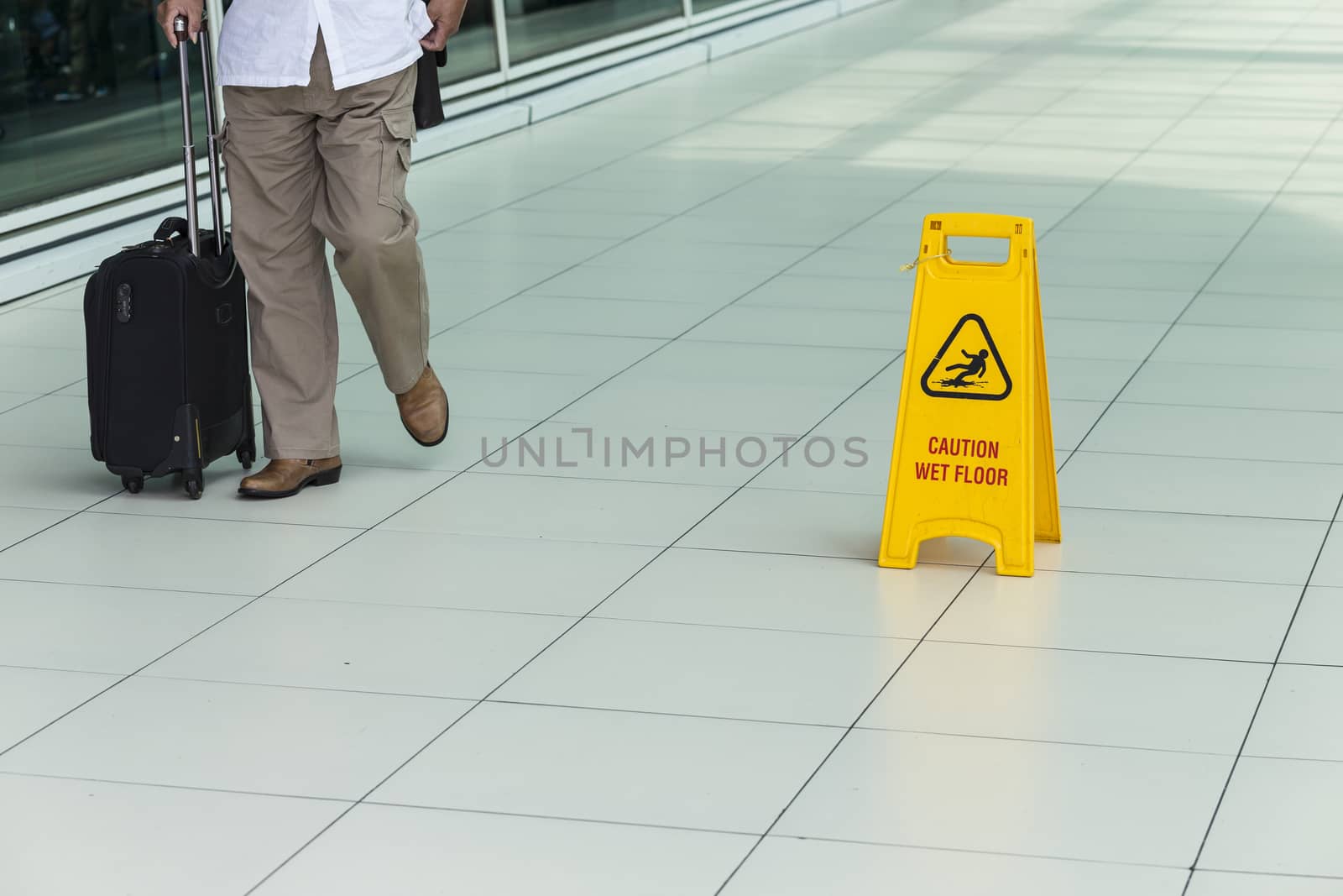 Yellow sign that alerts for wet floor in airport.