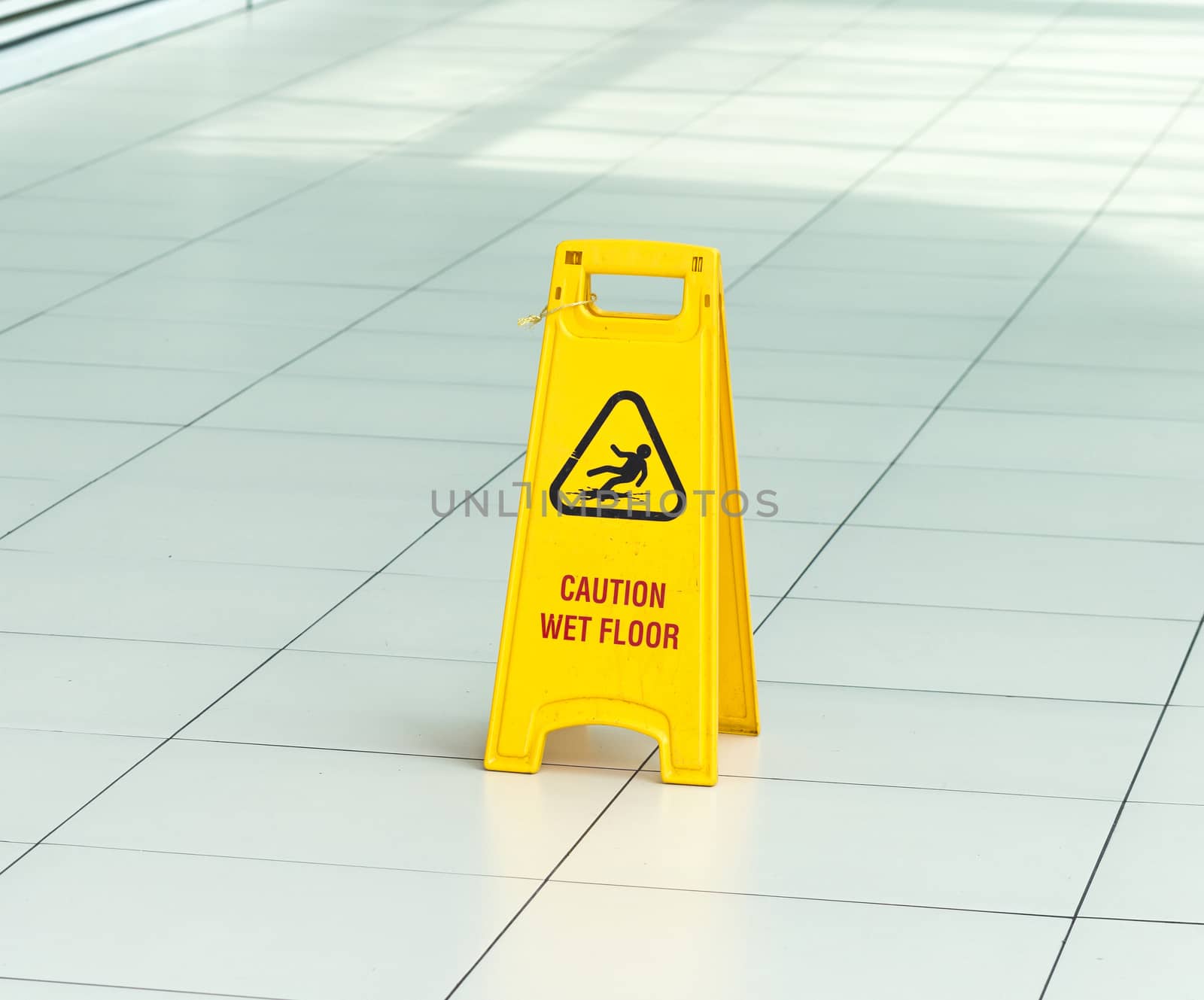 Yellow sign that alerts for wet floor in airport.