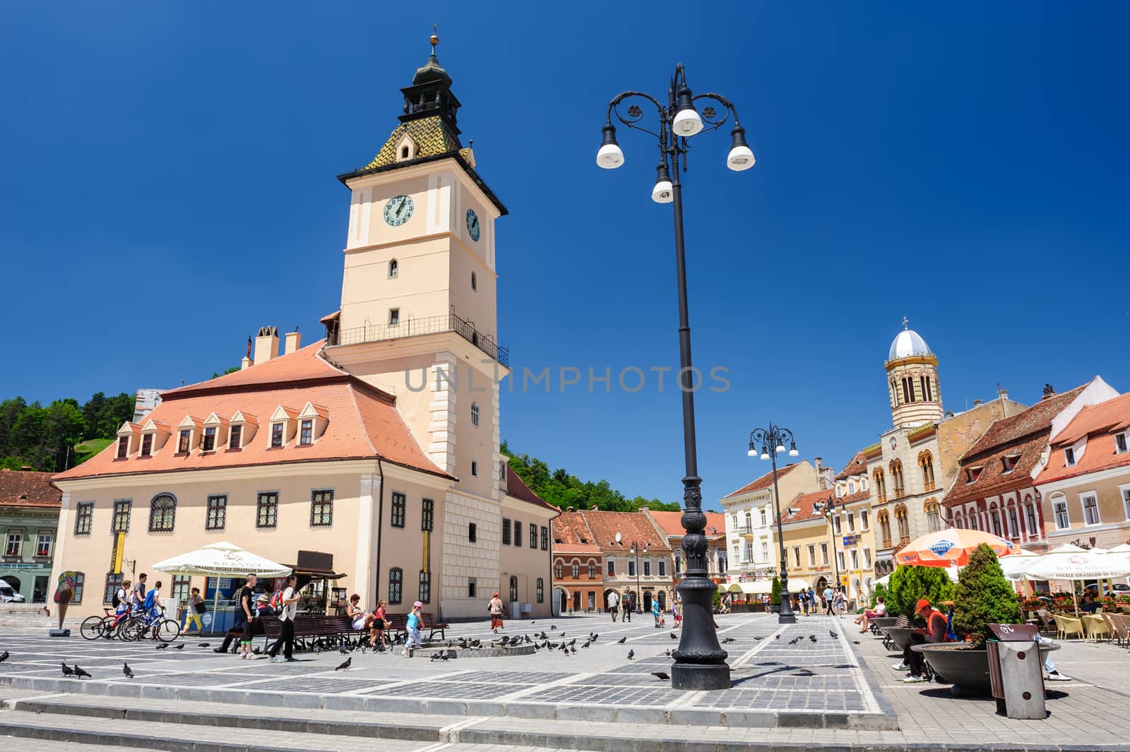 Brasov, Transylvania, Romania, 6th July 2015: rasov Council Square is historical center of city, people walkinng and sitting at outdoor terraces and restaurants.