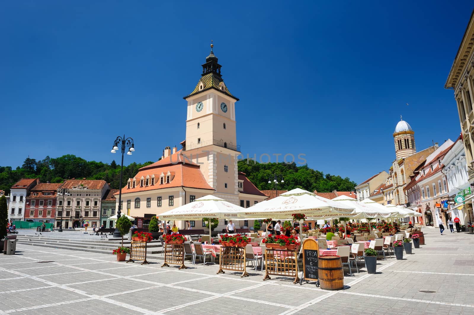 Brasov, Transylvania, Romania, 6th July 2015: rasov Council Square is historical center of city, people walkinng and sitting at outdoor terraces and restaurants.