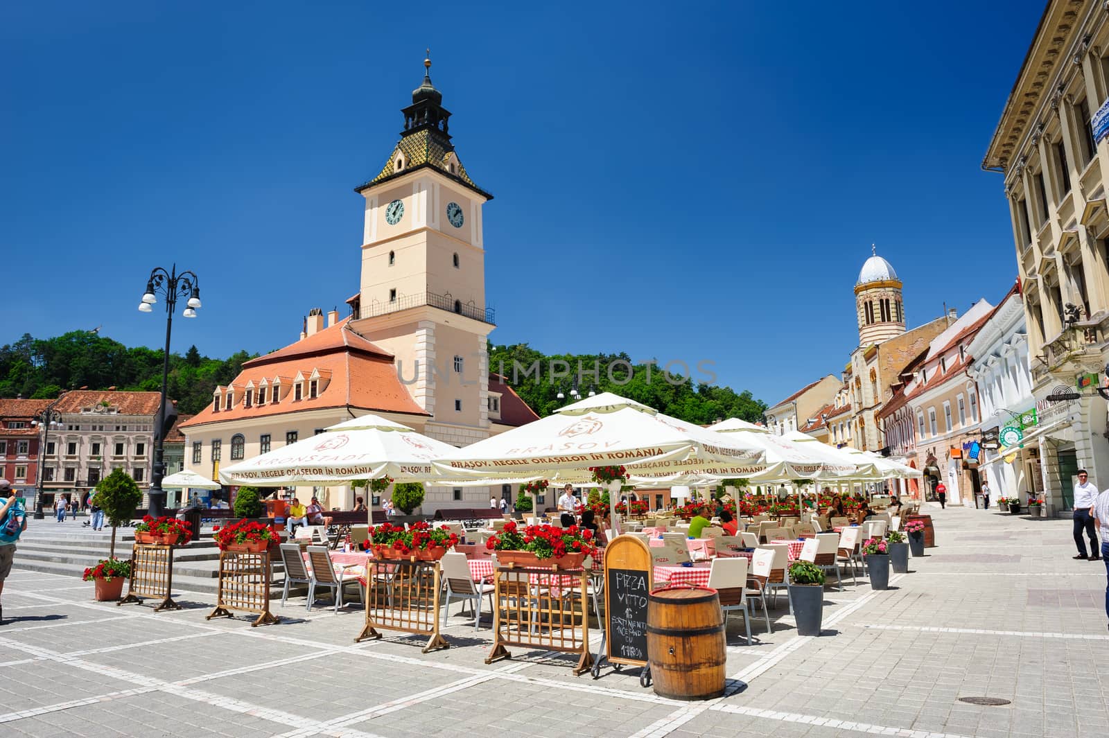 Brasov, Transylvania, Romania, 6th July 2015: rasov Council Square is historical center of city, people walkinng and sitting at outdoor terraces and restaurants.