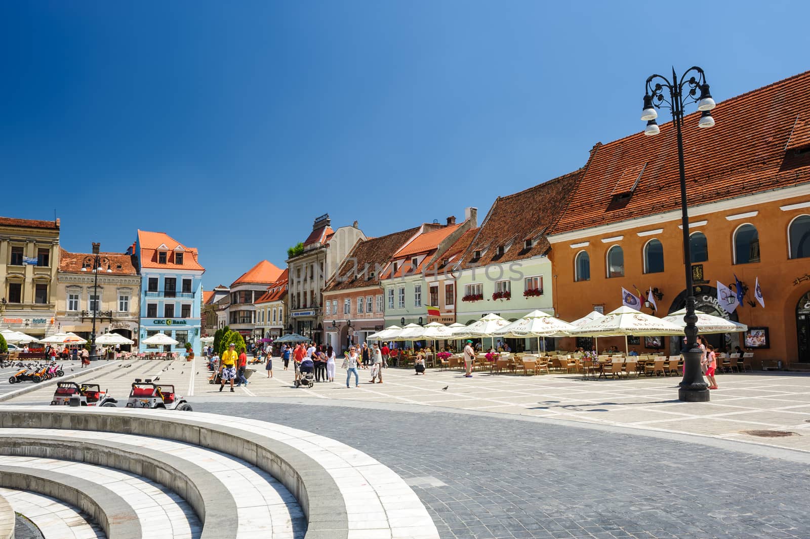 Brasov, Transylvania, Romania, 6th July 2015: Council Square is historical center of city, people walkinng and sitting at outdoor terraces and restaurants.