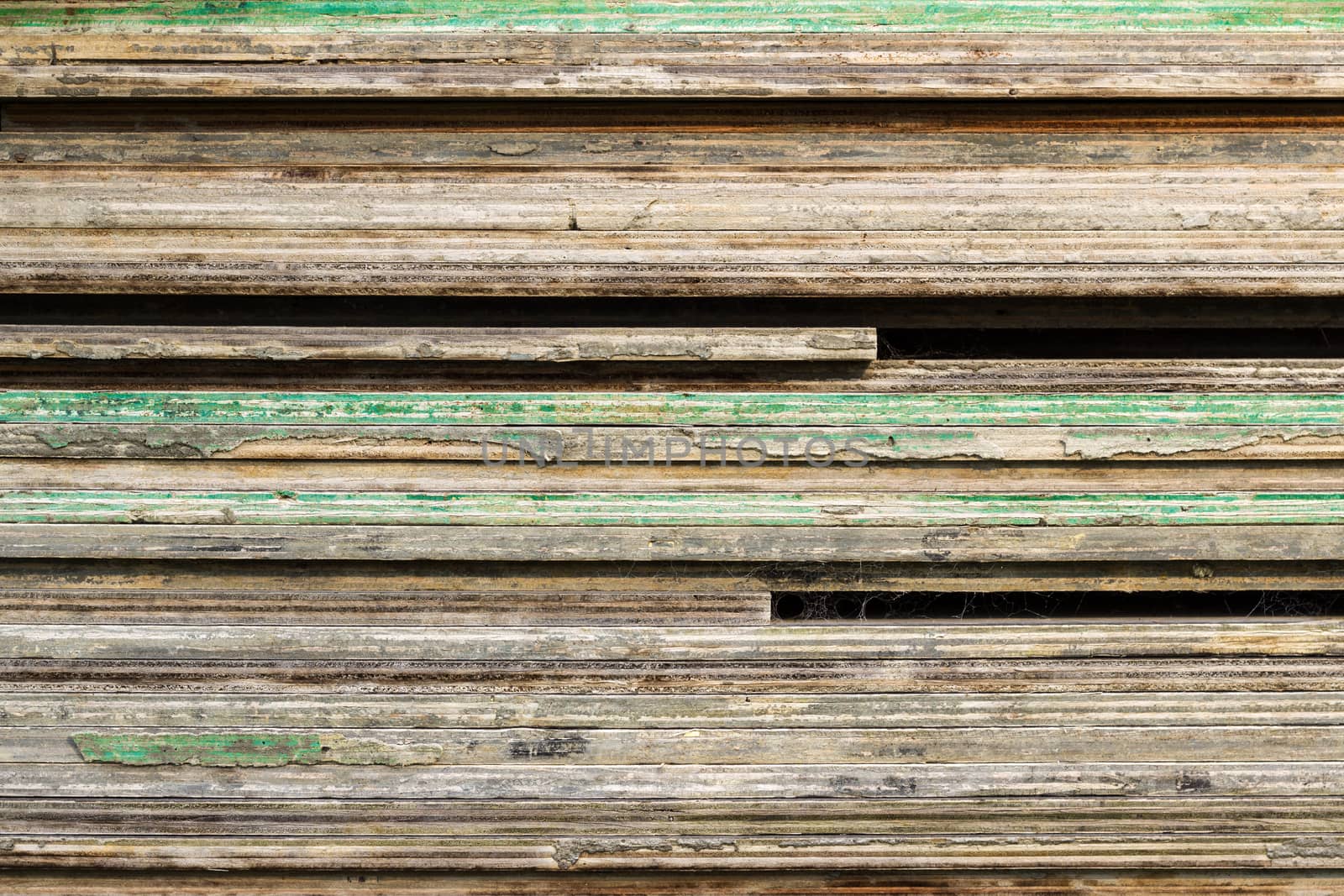 timber planks layered on top of each other with green paint splotches.