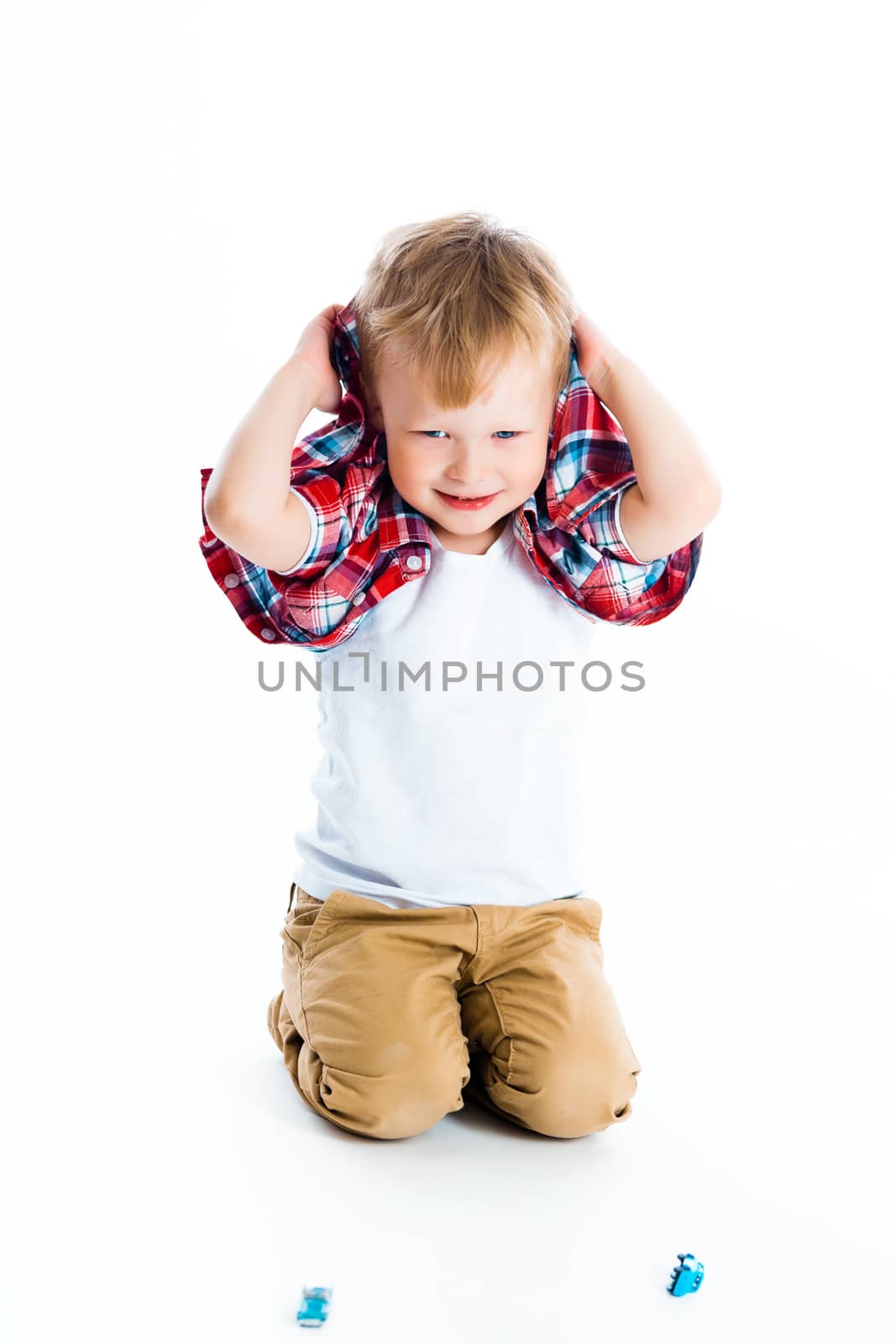 Little cheerful blue-eyed boy on a white background