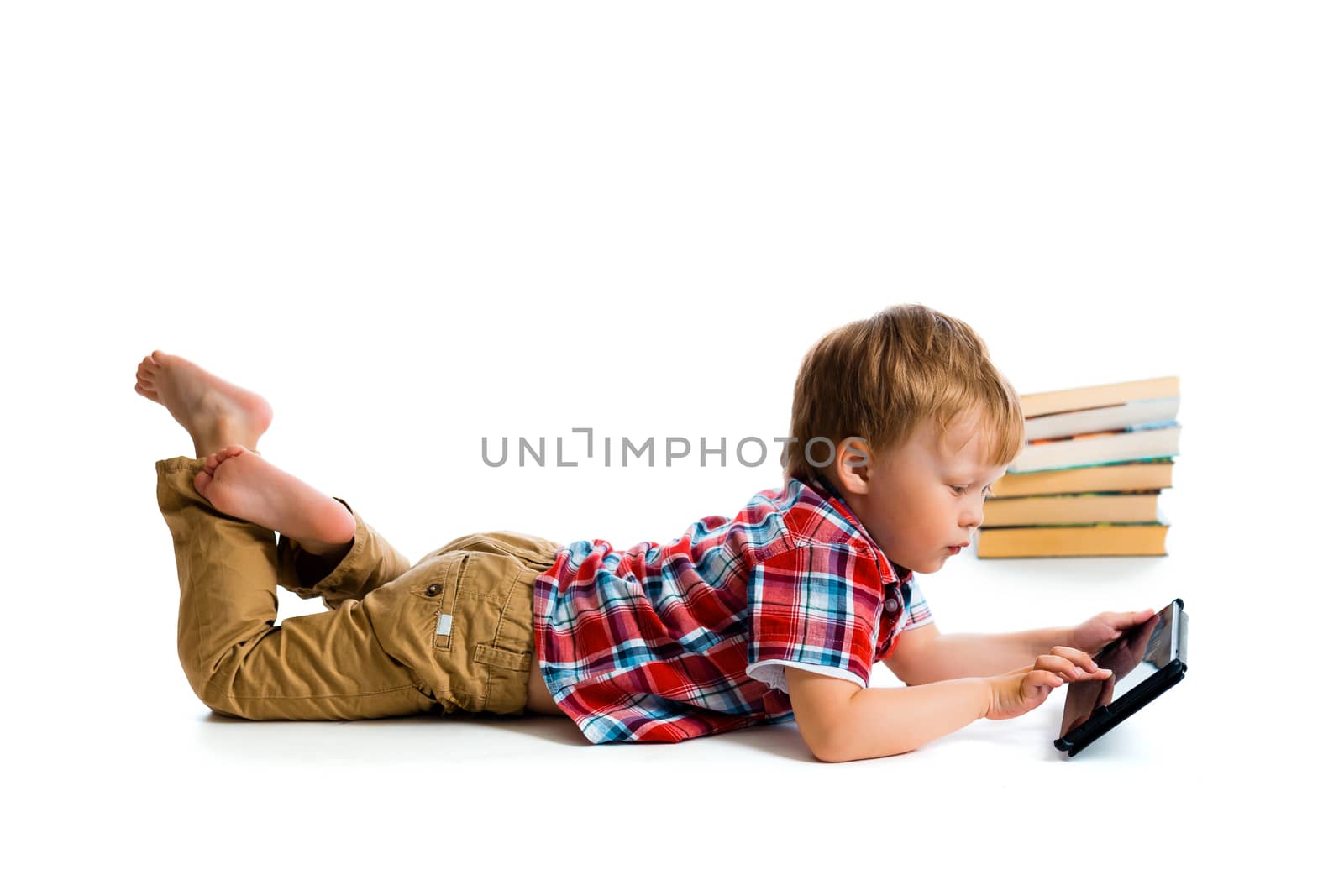 A small boy with tablet computer and books on white background