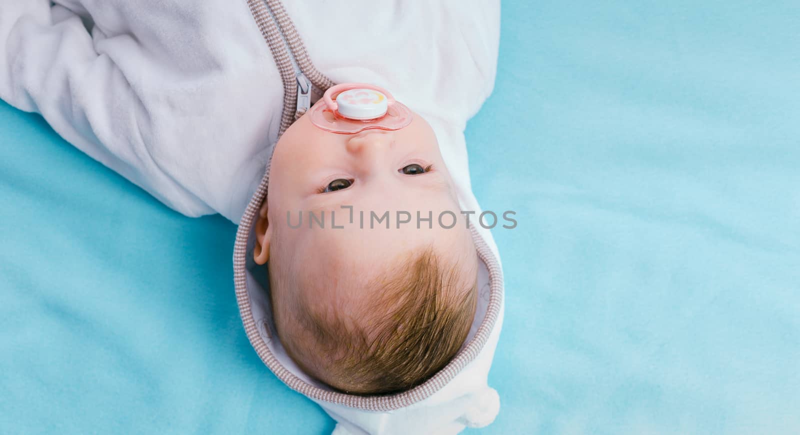 Baby in the hood on a blue blanket