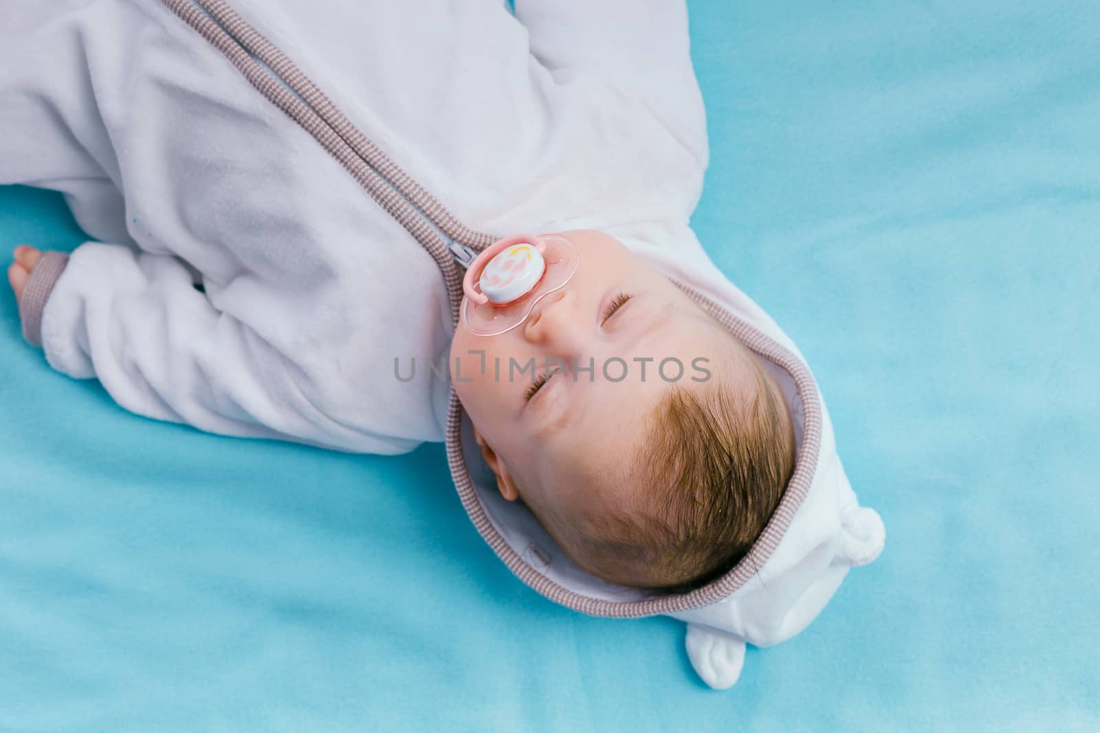 Baby in the hood on a blue blanket