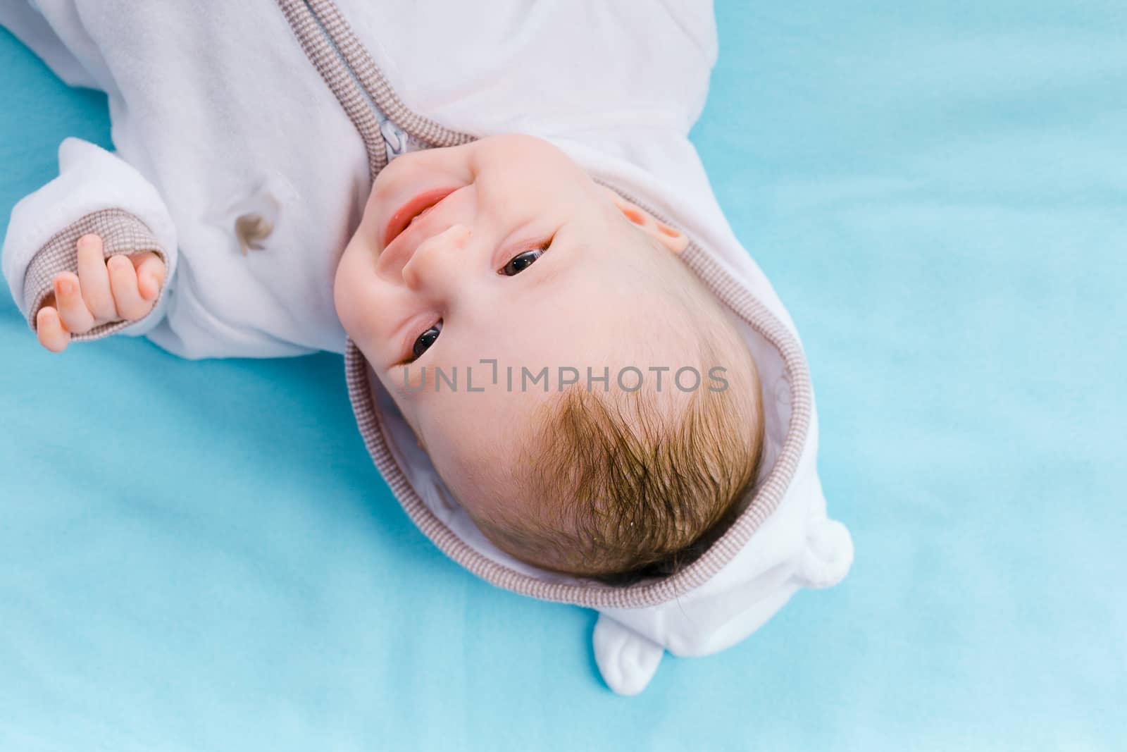 Happy Baby in the hood on a blue blanket