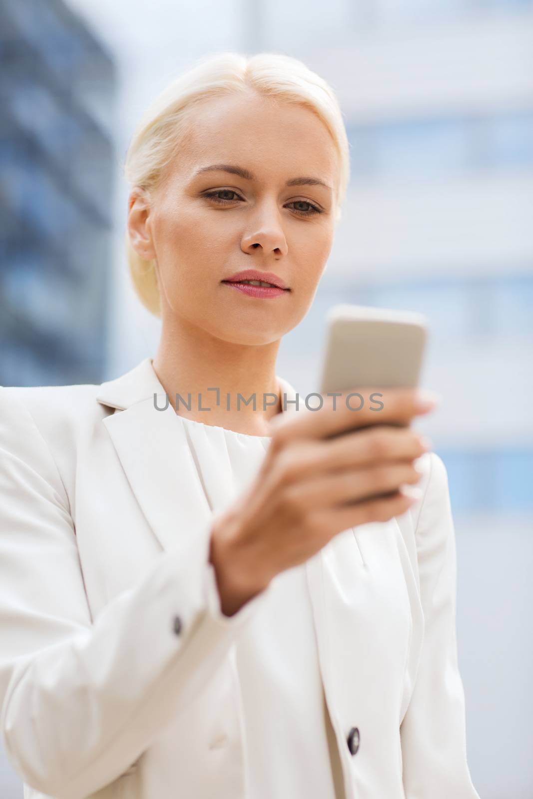 serious businesswoman with smartphone outdoors by dolgachov