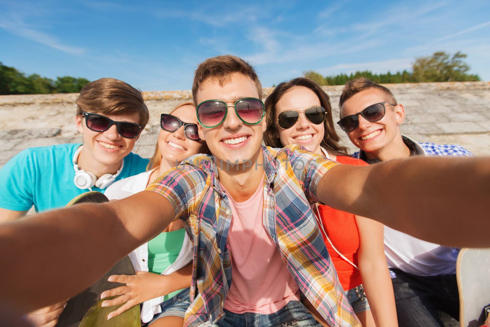 group of smiling friends making selfie outdoors by dolgachov