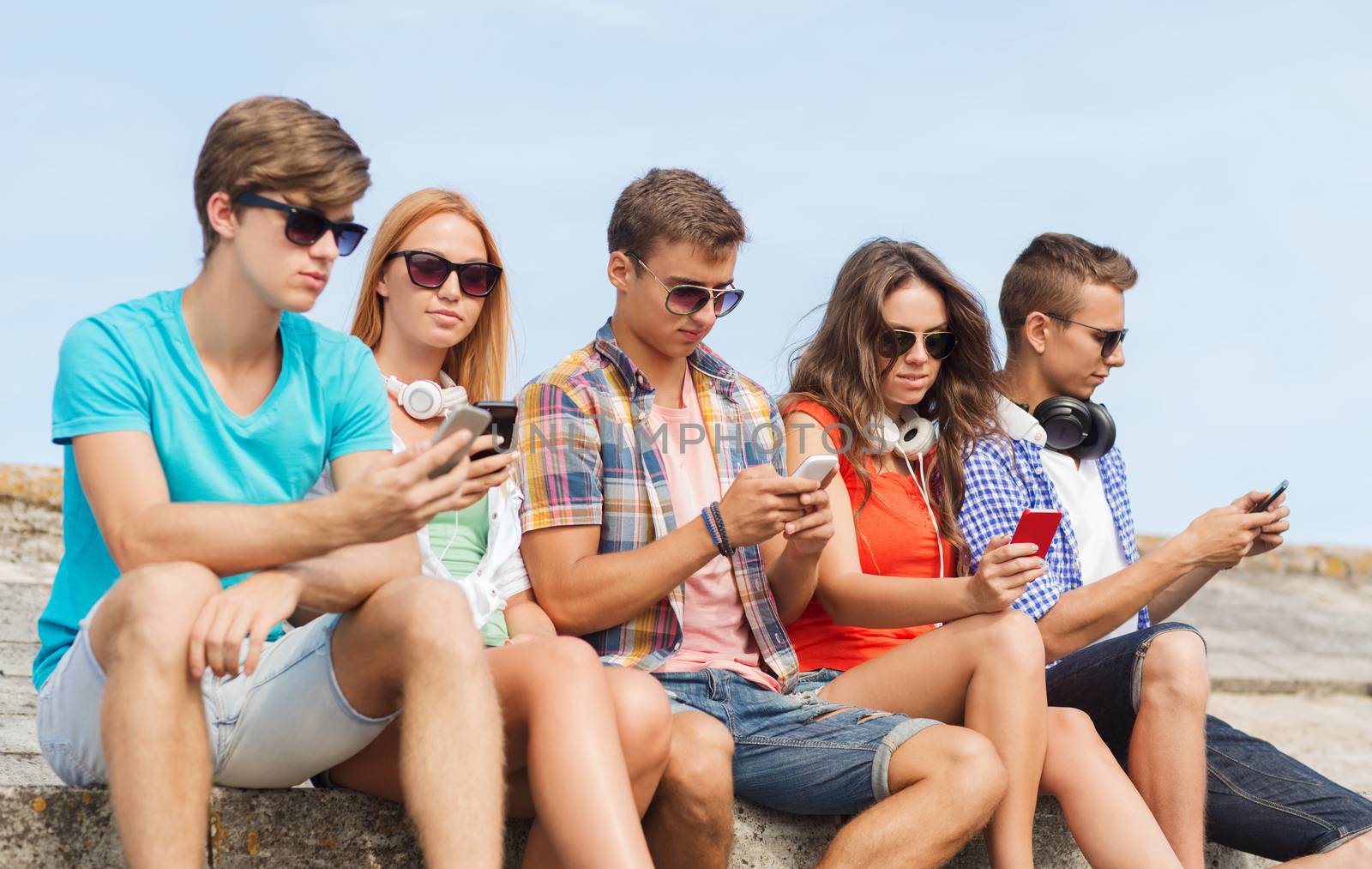 group of friends with smartphones outdoors by dolgachov