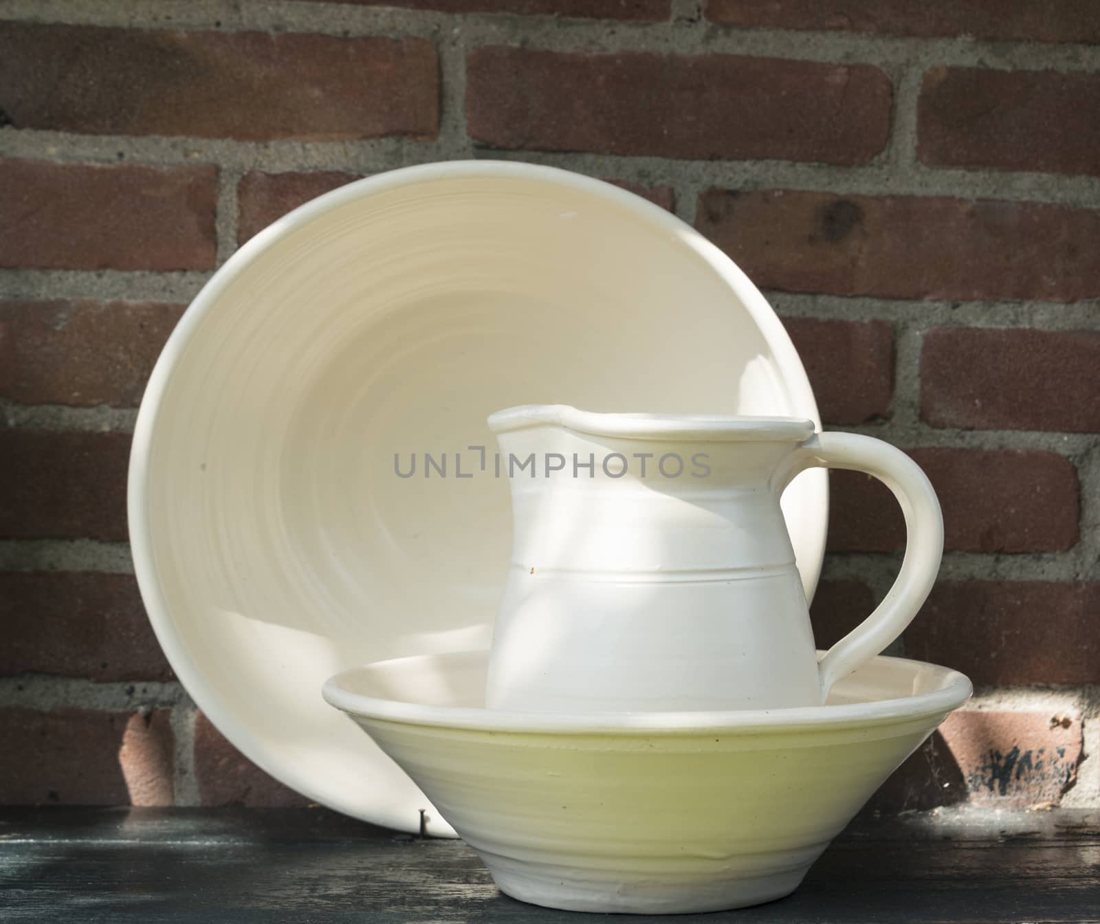 white clay pottery with stone wall background