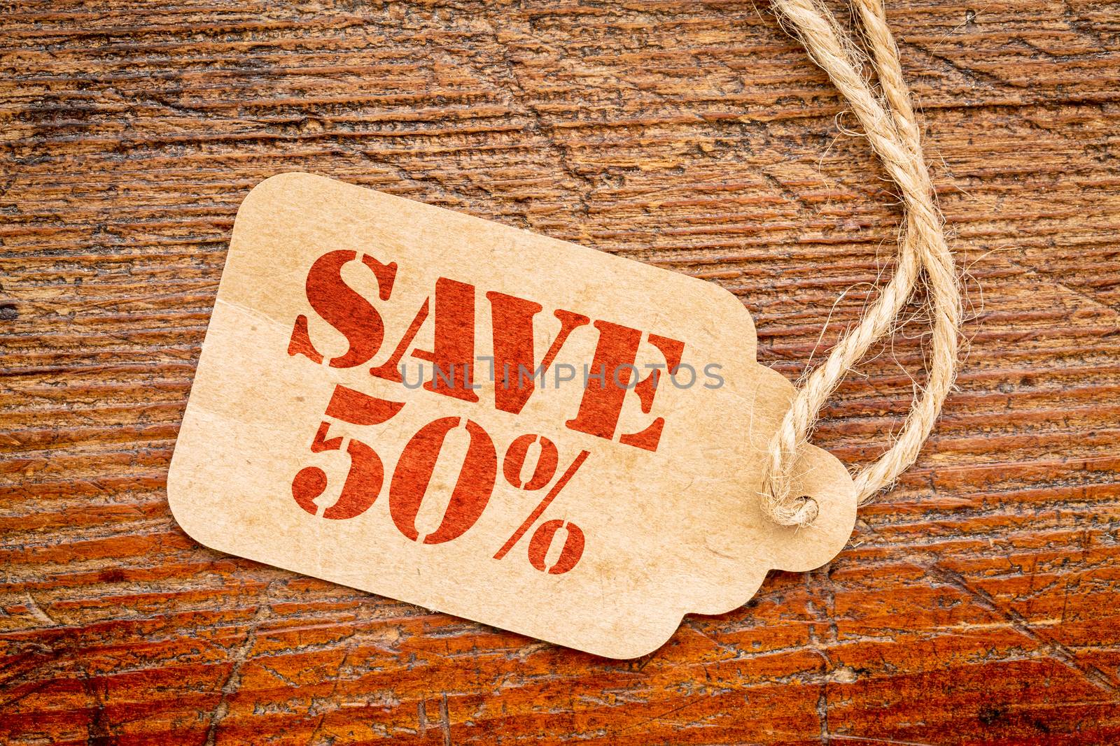 save 50 percent  sign a paper price tag against rustic red painted barn wood - shopping concept