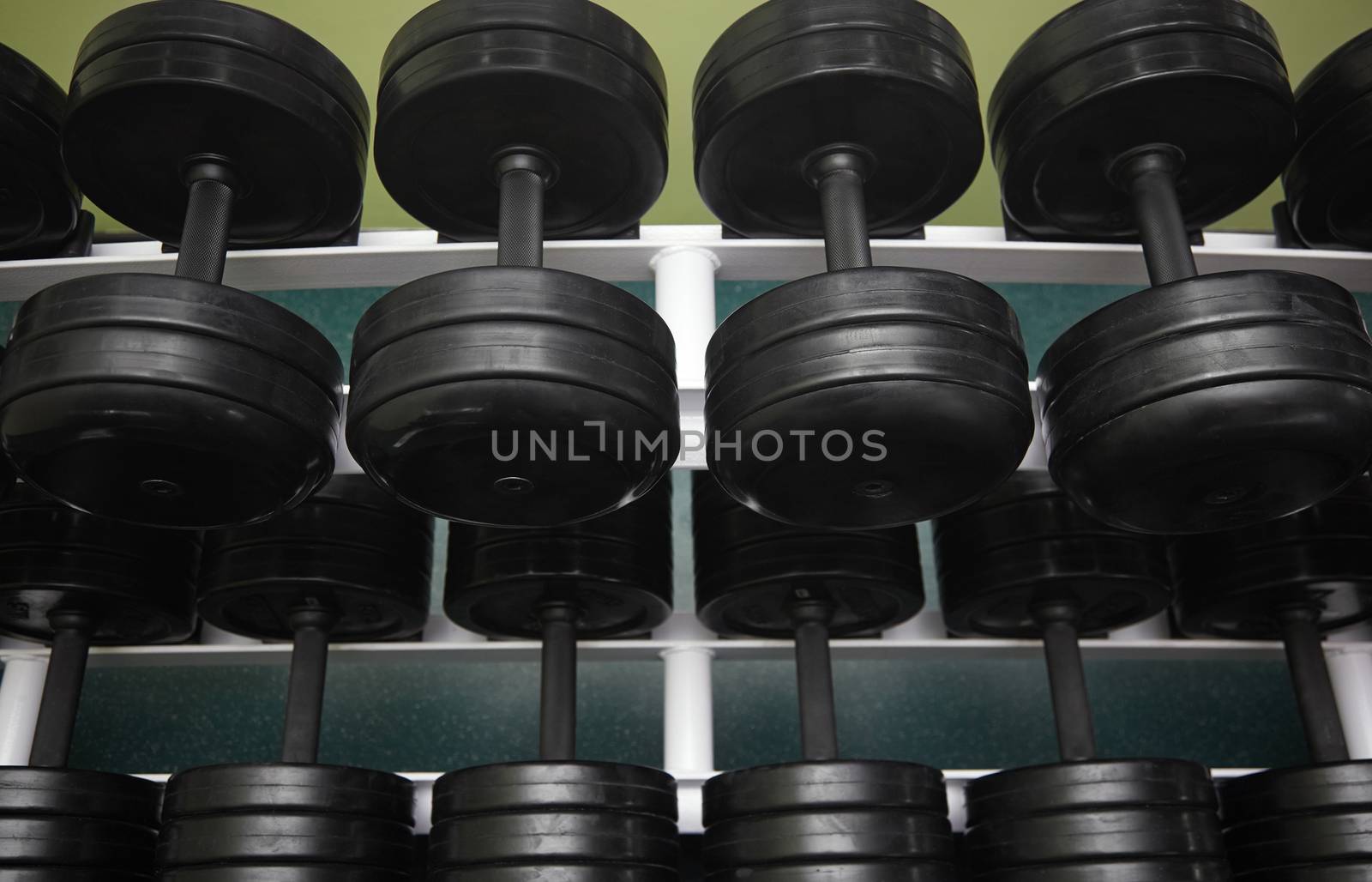 Group of black barbells arranged in row at the gym. Horizontal photo